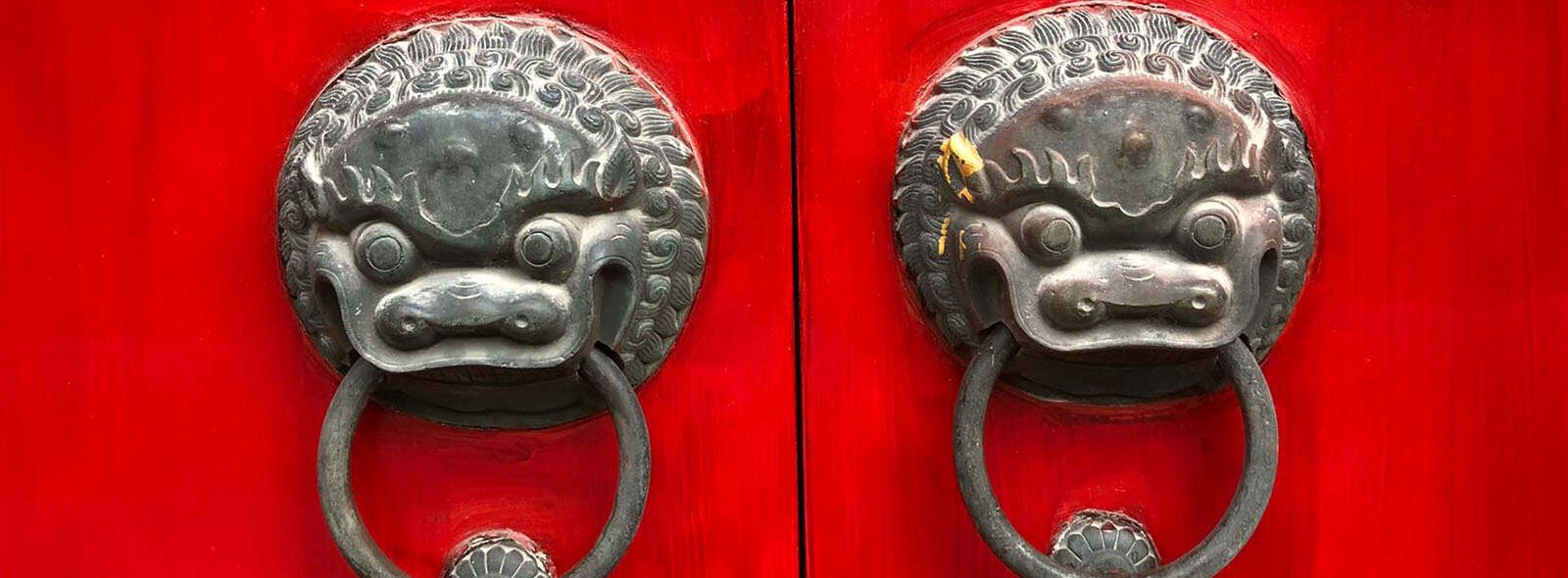 2 rode deuren met deurknoppen met leeuwenkop
