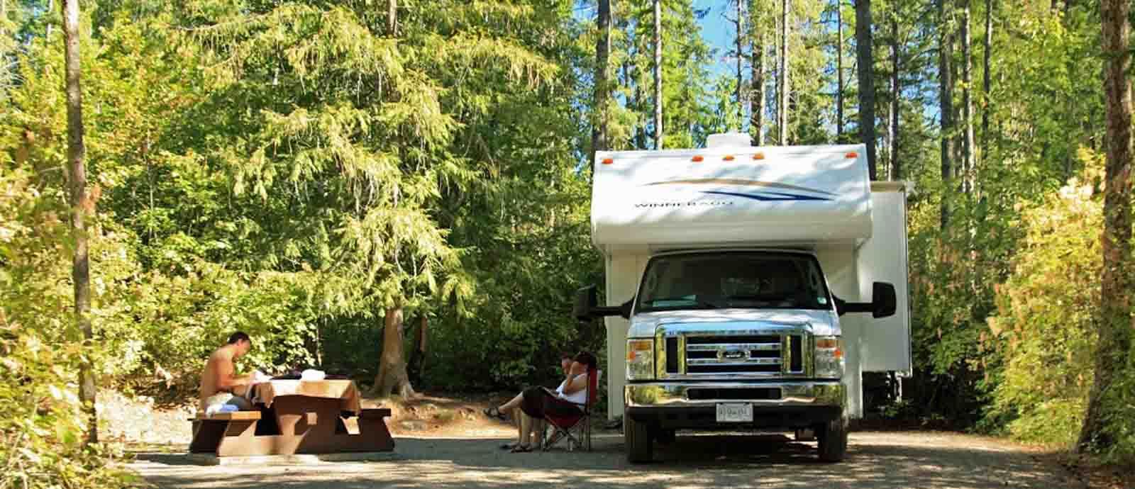 Witte camper in bossen Canada met picknick tafel