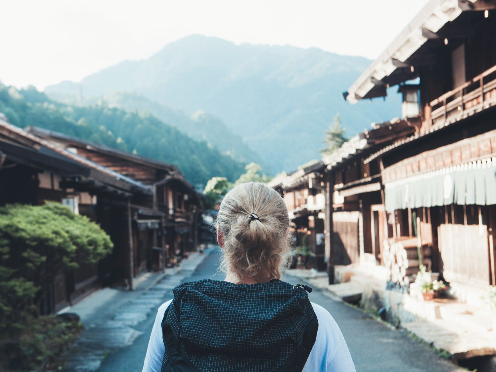 Rondreis Japan, Nakasendo Trail, wandelaar met stad en bergen
