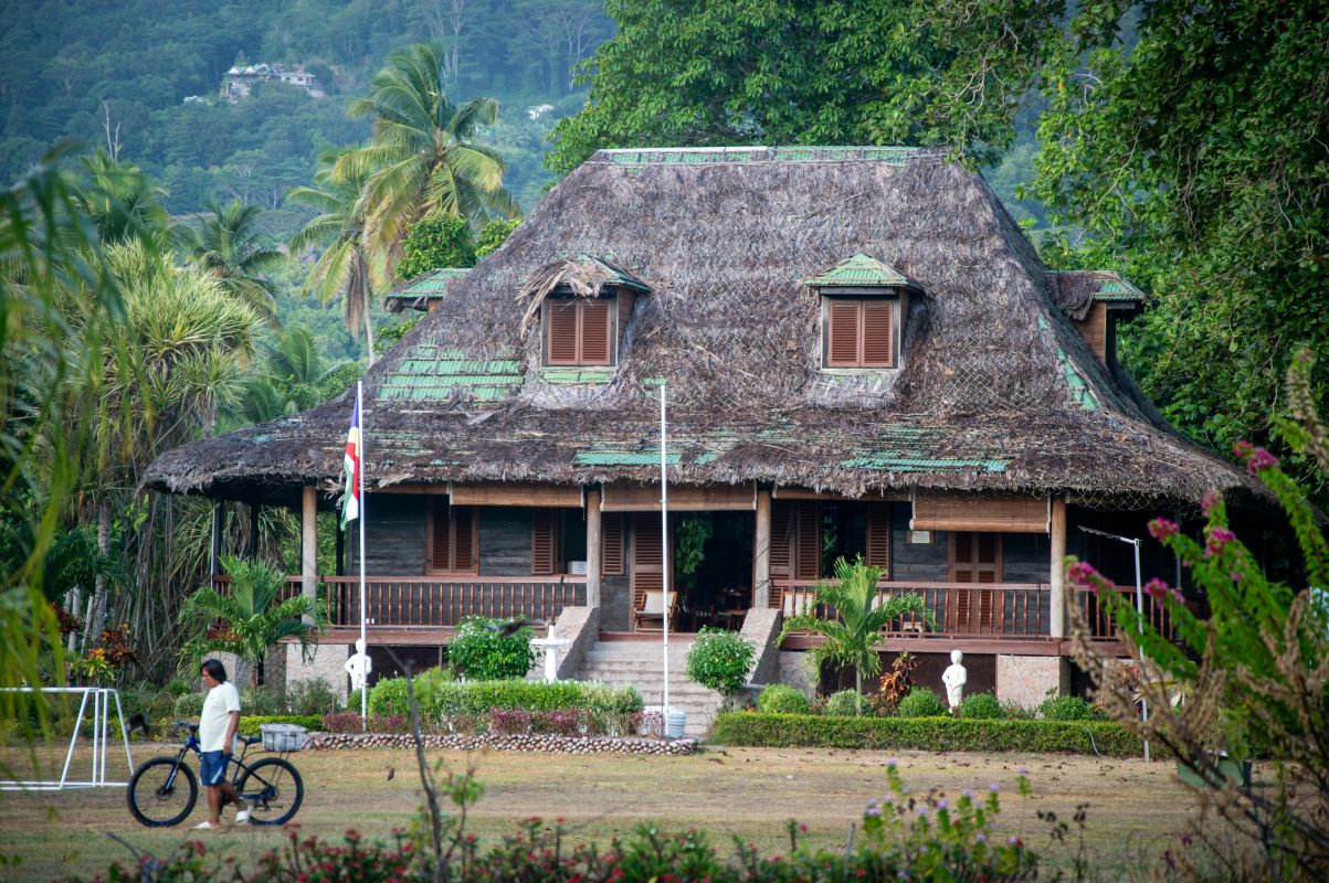 Rondreis Seychellen, huis met rieten dak en man met fiets