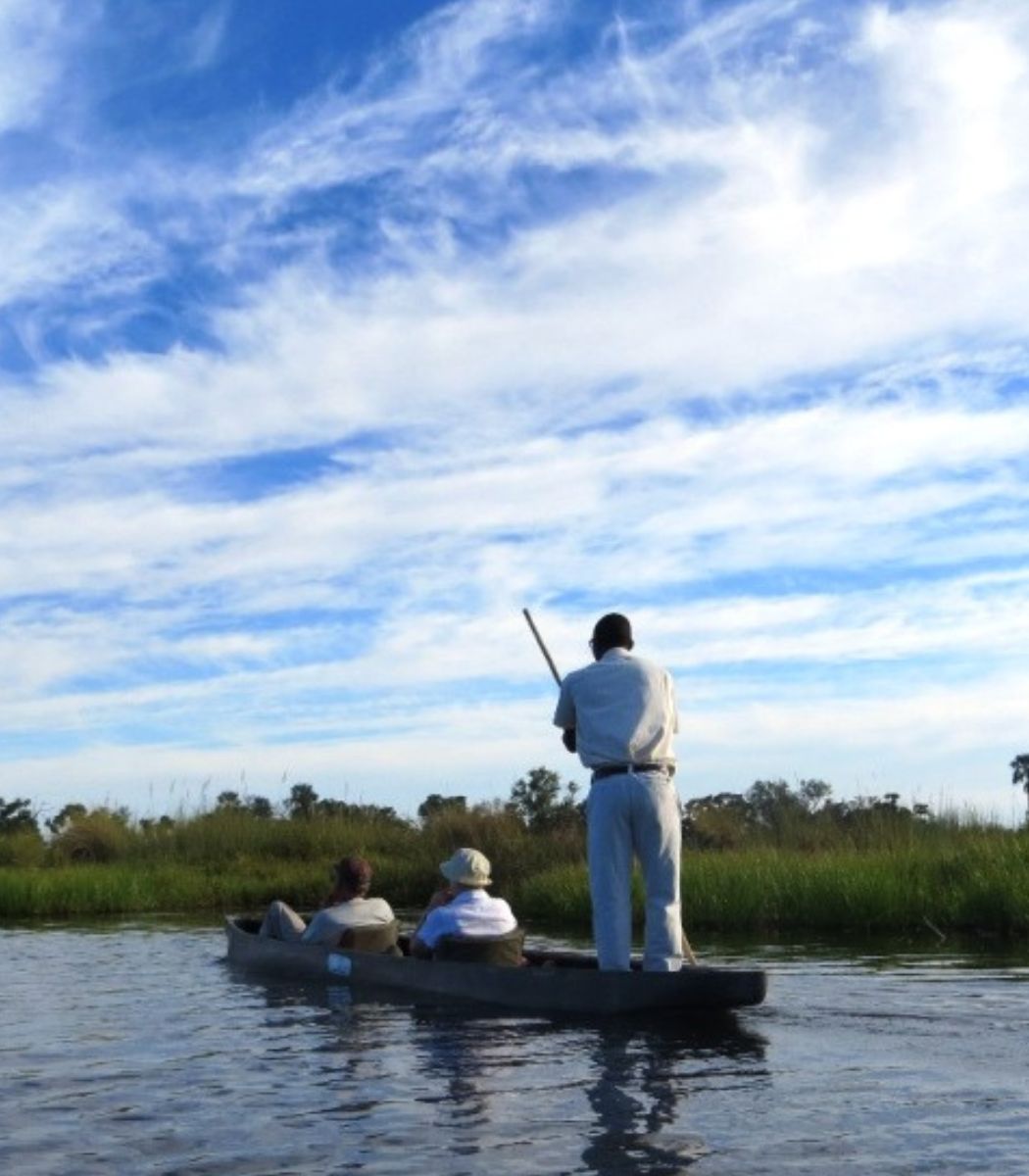 Mensen varen in een mokoro in de Okavango Delta in Botswana