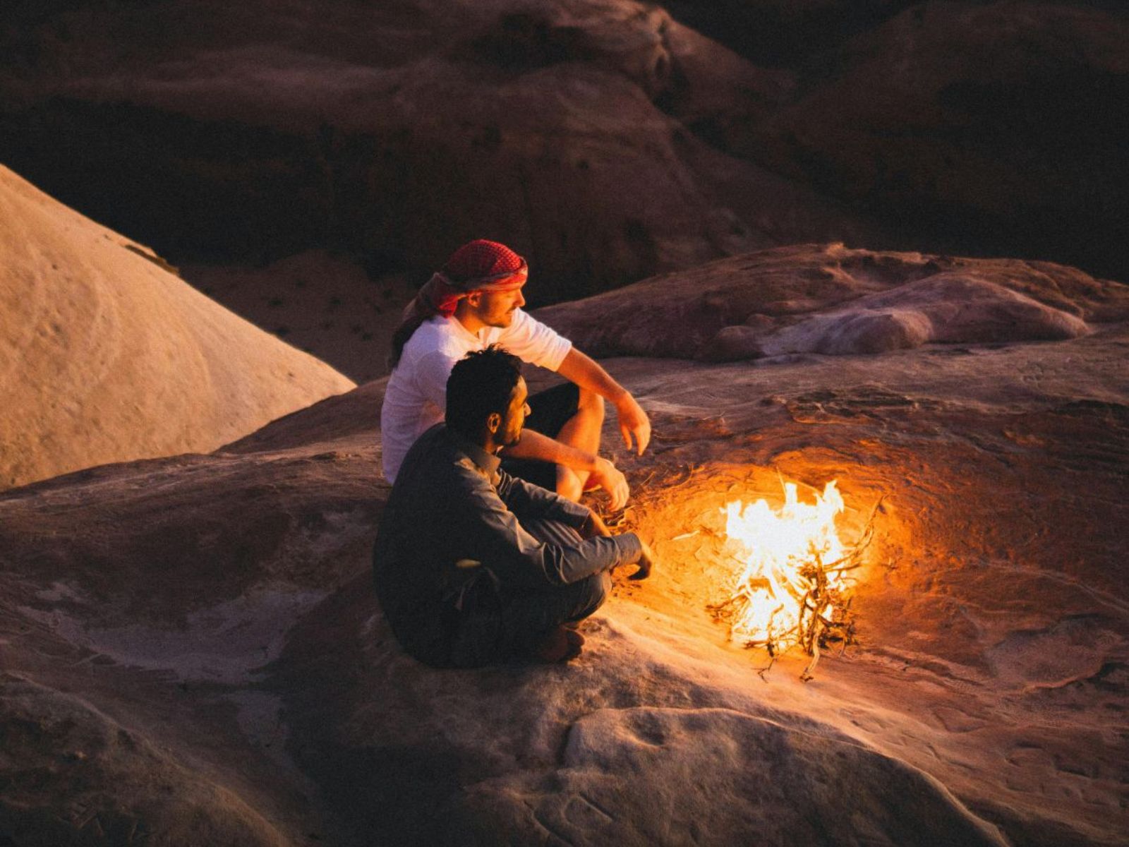 Mensen rond kampvuur in de Wadi Rum in Jordanië
