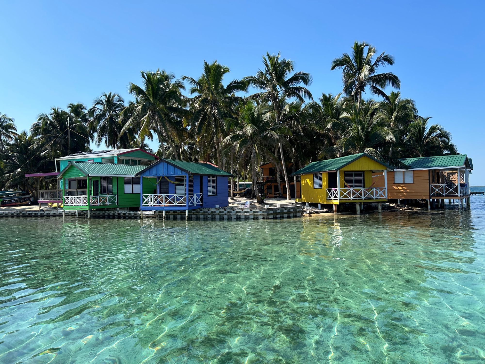 Rondreis Belize, Tobacco Caye, kleurige houten huisjes aan het strand