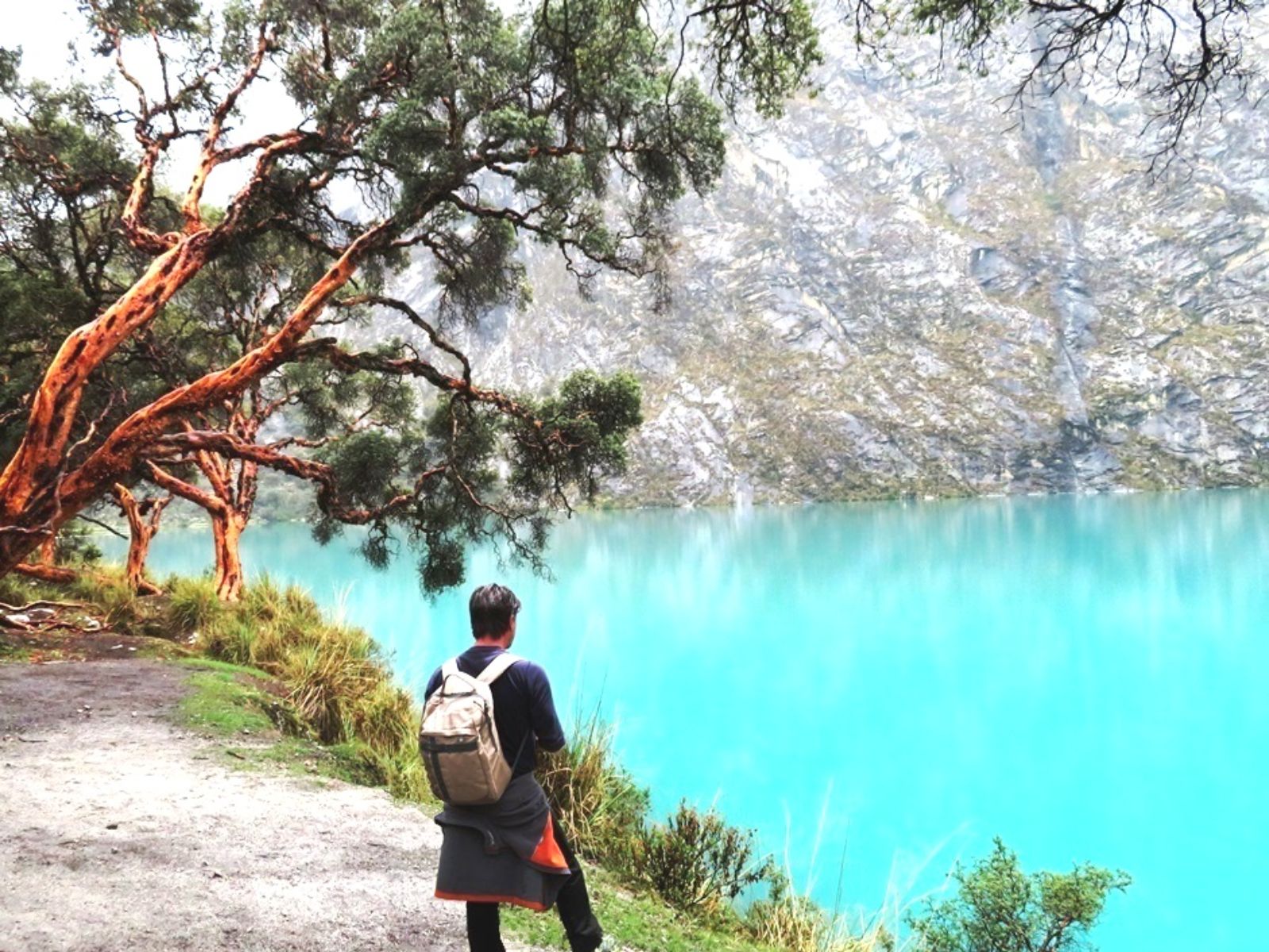 Rondreis Peru, Huaraz, meer met persoon en berg op achtergrond
