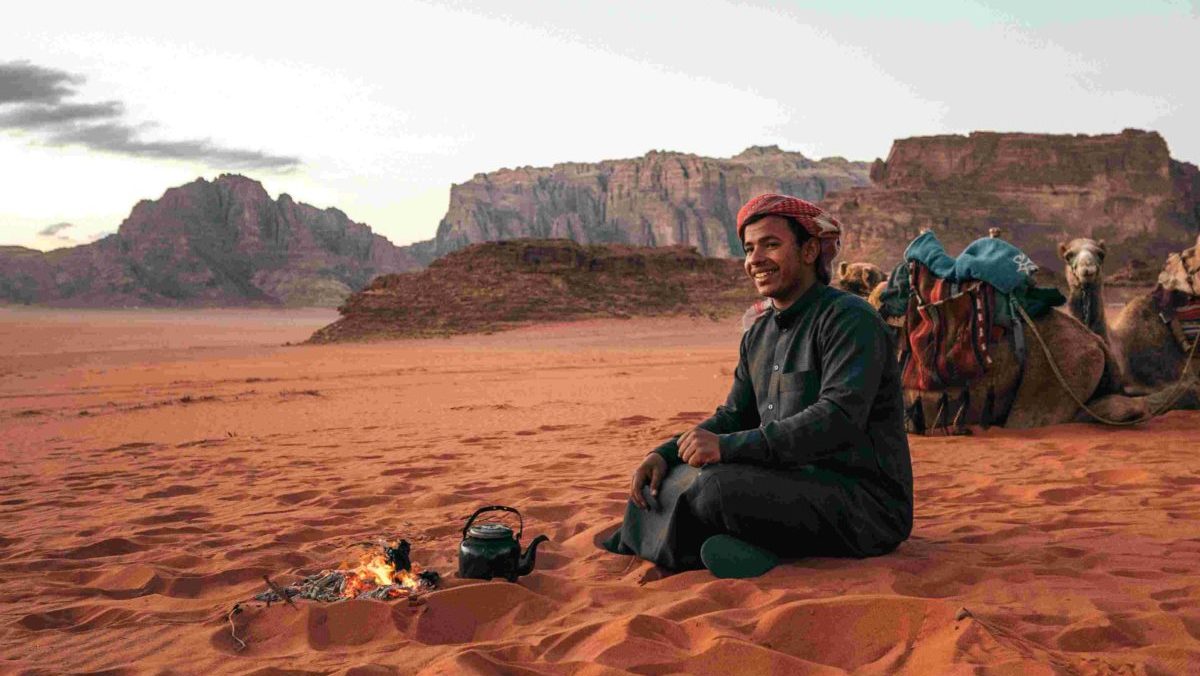 Rondreis Jordanië, Wadi Rum, zittende man naast een kampvuur
