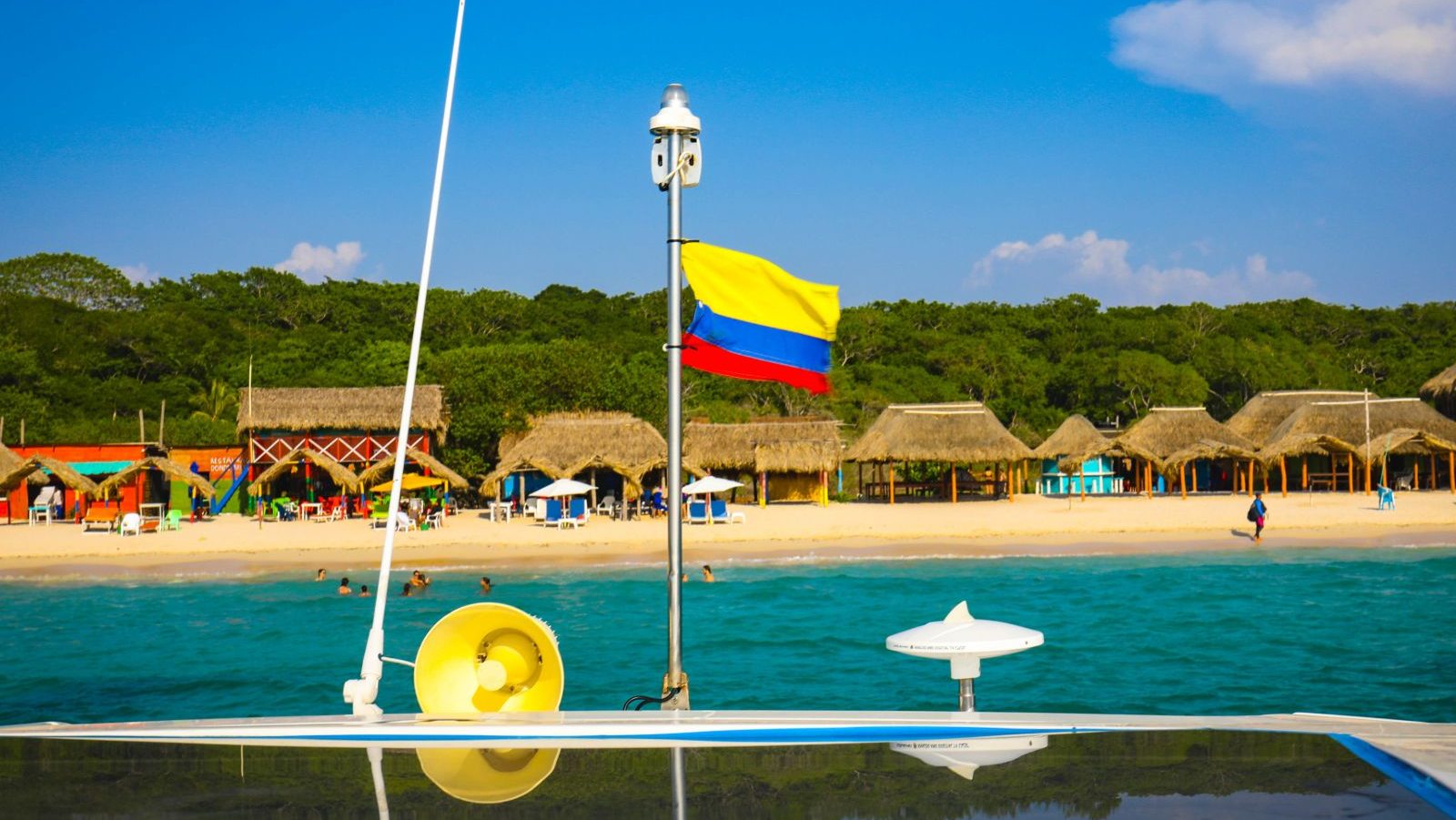Rondreis Colombia, Rosario eilanden, boot met vlag en strand