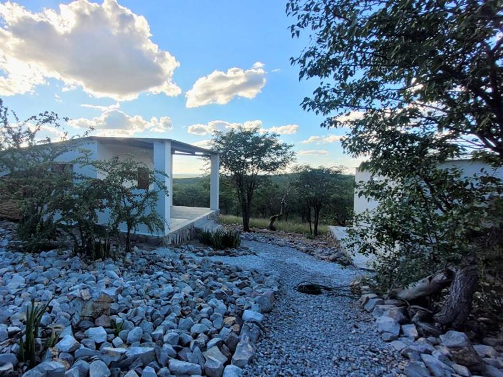 Rondreis Namibie, Etosha National park, Mondjila Safari Camp, chalet buitenaanzicht met stenen tuin