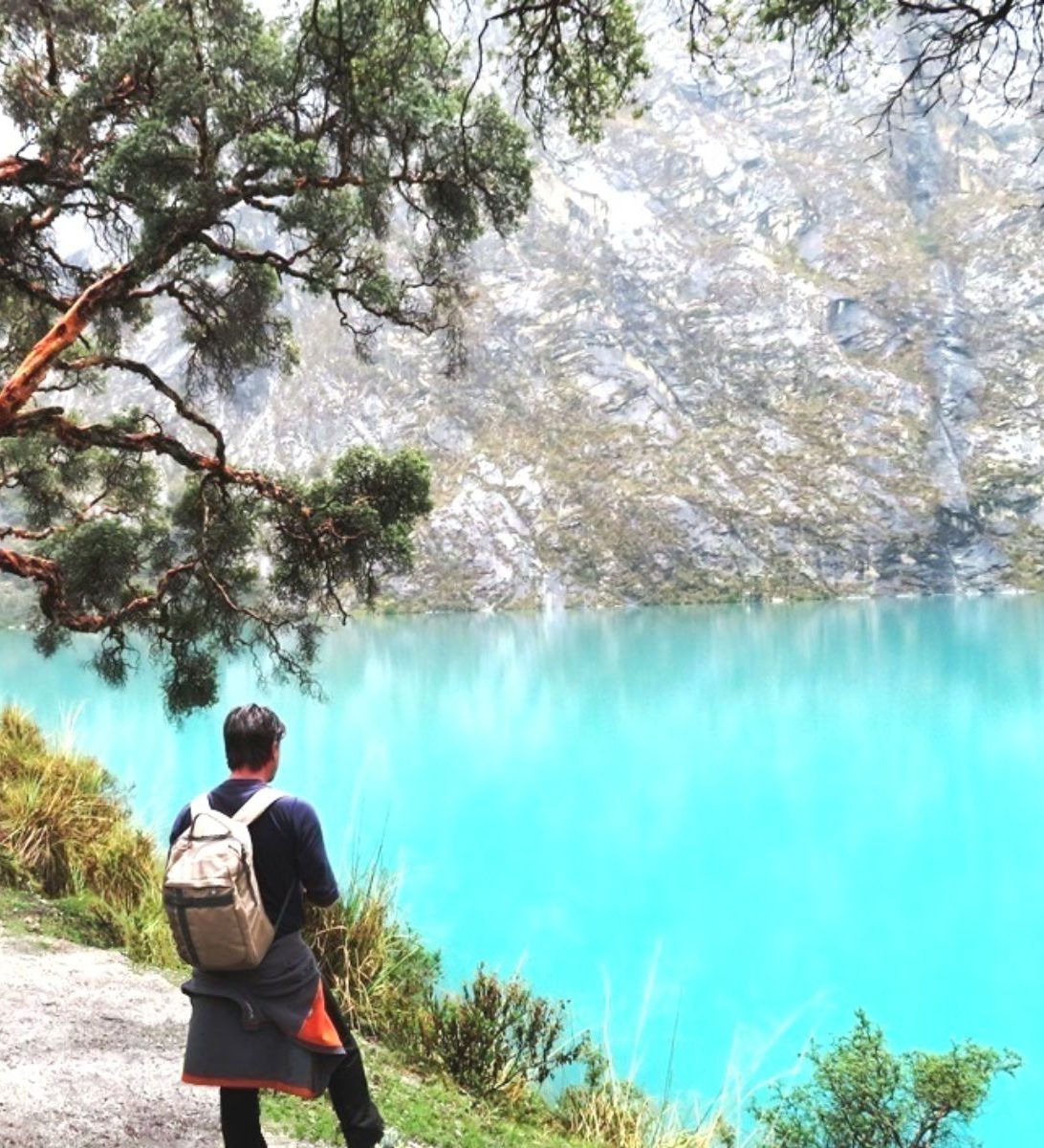 Rondreis Peru, Huaraz, meer met persoon en berg op achtergrond