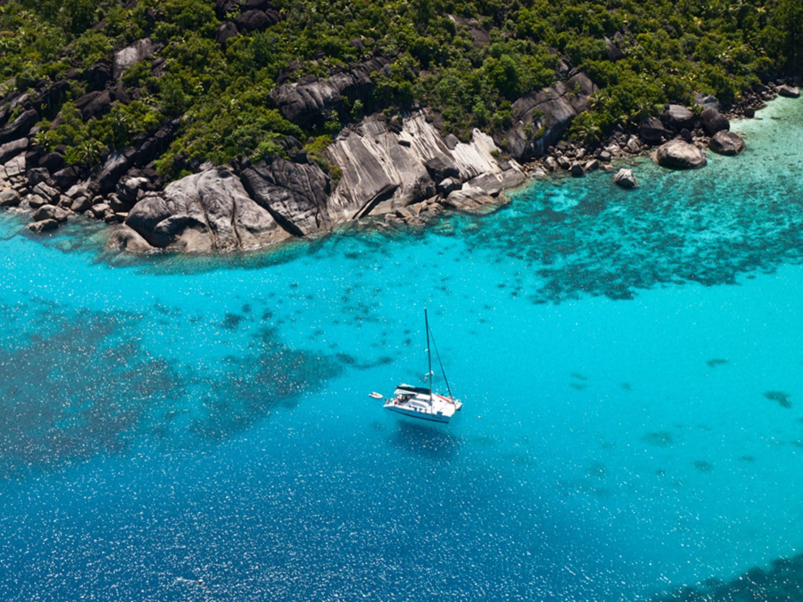 Rondreis Seychellen, zeilboot in helderblauw water