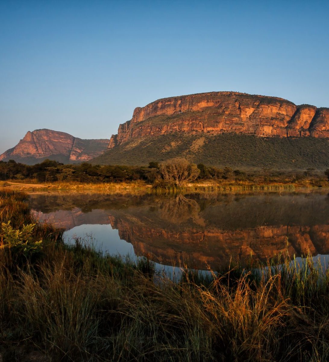 Rondreis Zuid-Afrika, Entabeni Game Reserve, zonsopkomst in een landschap met bergen en een meer