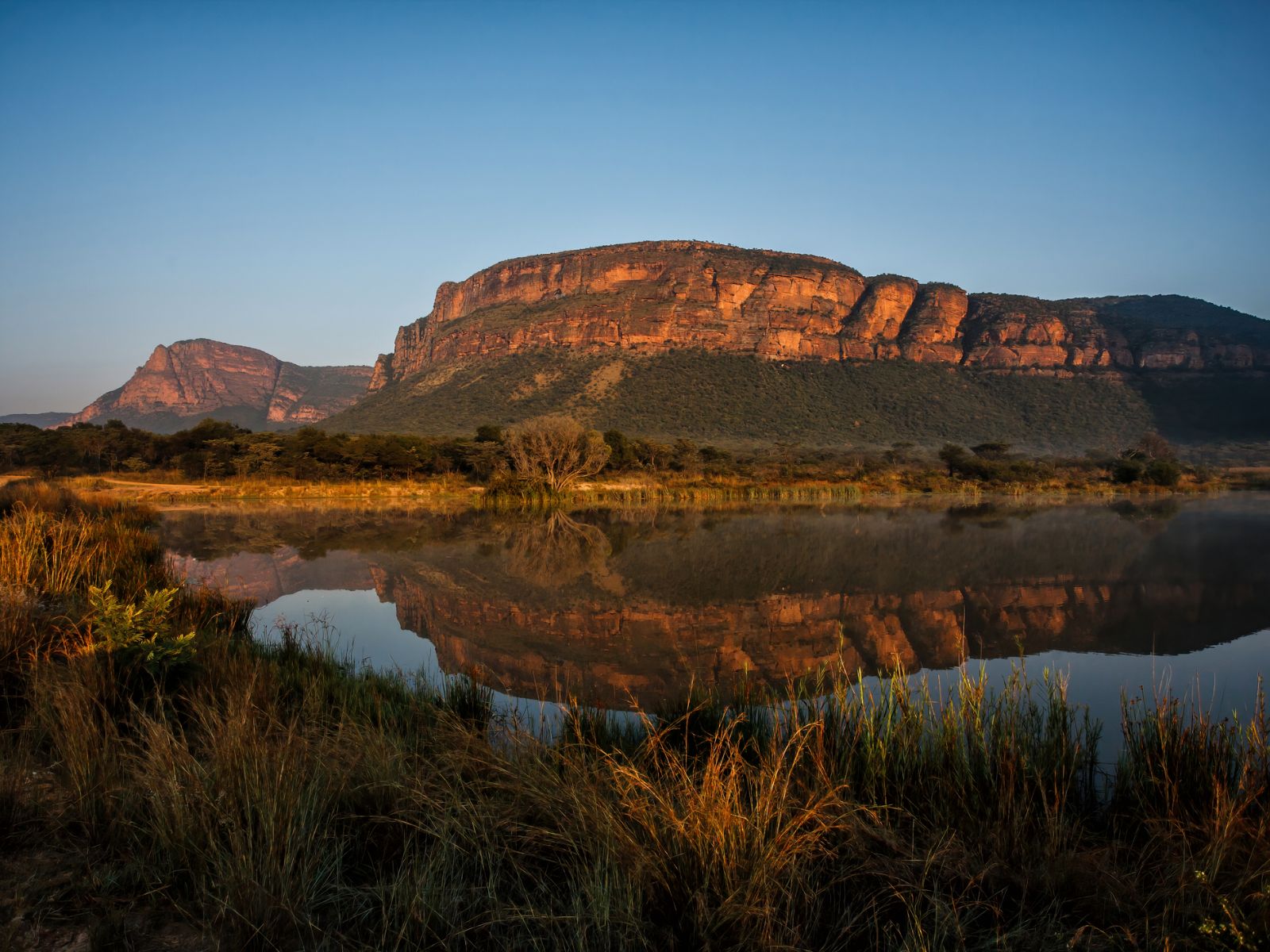 Rondreis Zuid-Afrika, Entabeni Game Reserve, zonsopkomst in een landschap met bergen en een meer