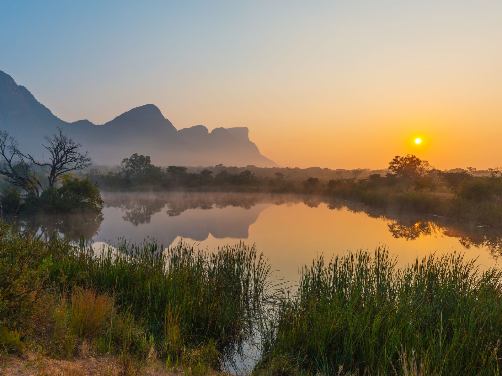 Rondreis Zuid-Afrika, Entabeni Game Reserve, zonsopkomst in een landschap met bergen en meer