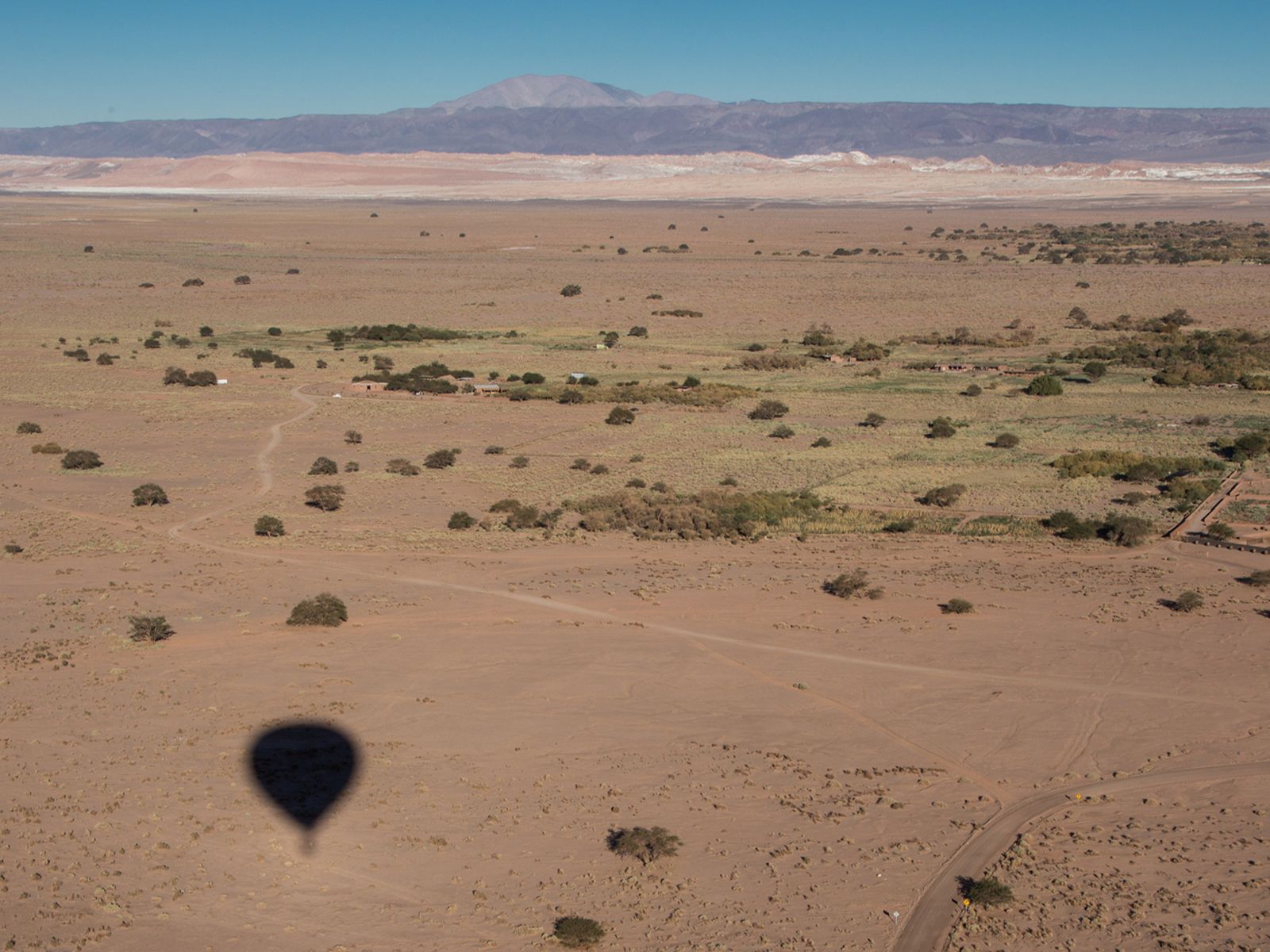 Rondreis Chili, Atacama, schaduw van luchtballon in de woestijn