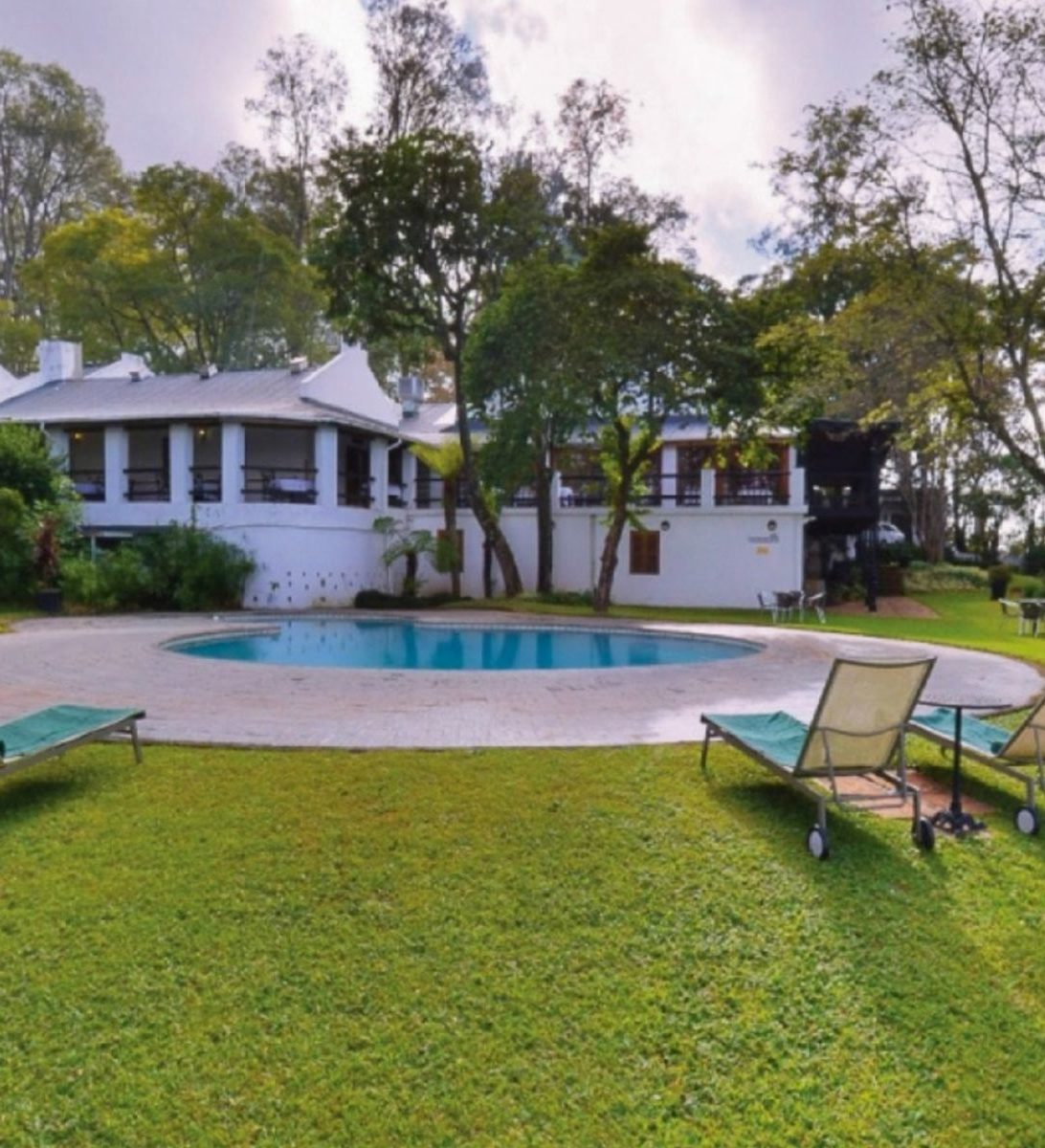 Rondreis Zuid-Afrika, Tzaneen, Coach House Hotel & Spa, buitenaanzicht hotel met zwembad
