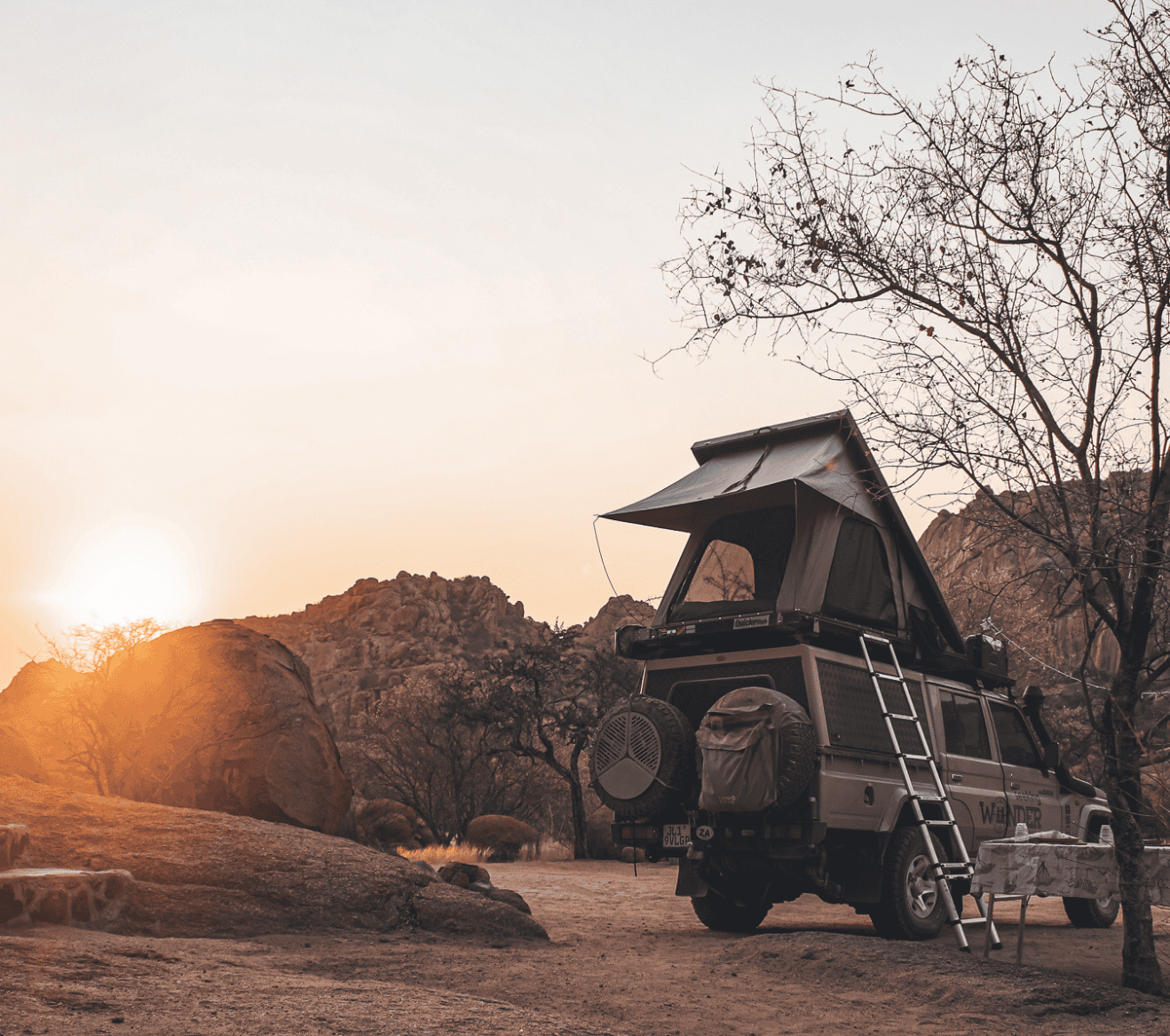 rondreis camping expeditie door namibie en zuid afrika range rover met daktent bij zonsondergang