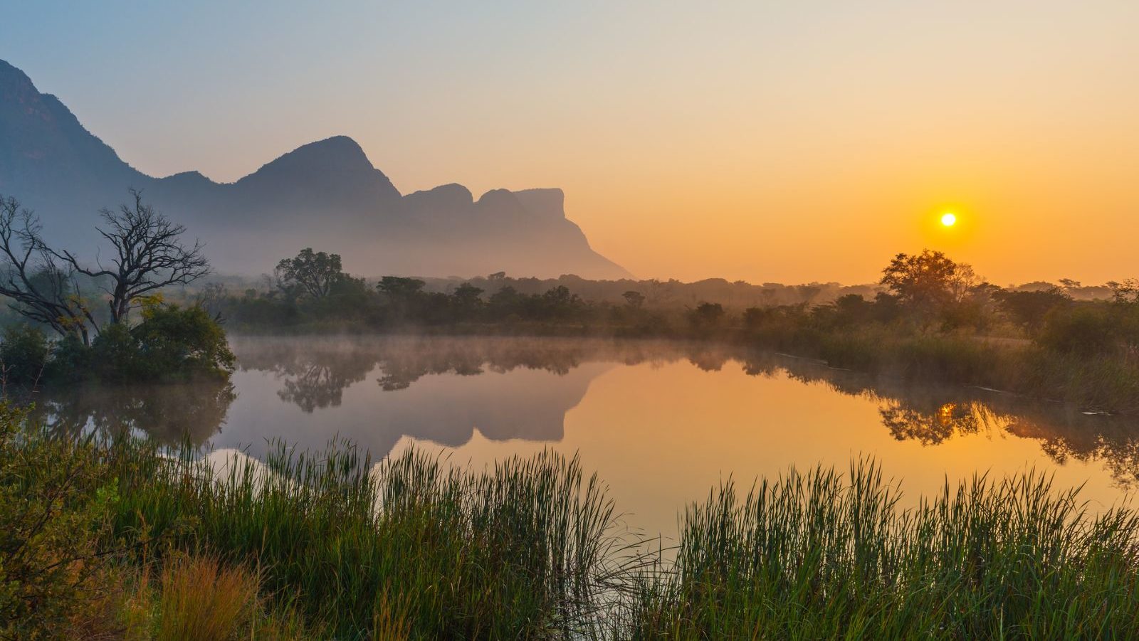 Rondreis Zuid-Afrika, Entabeni Game Reserve, zonsopkomst in een landschap met bergen en meer