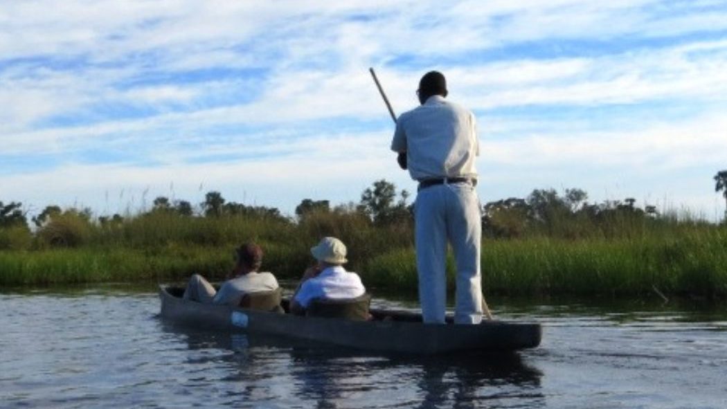Mensen varen in een mokoro in de Okavango Delta in Botswana