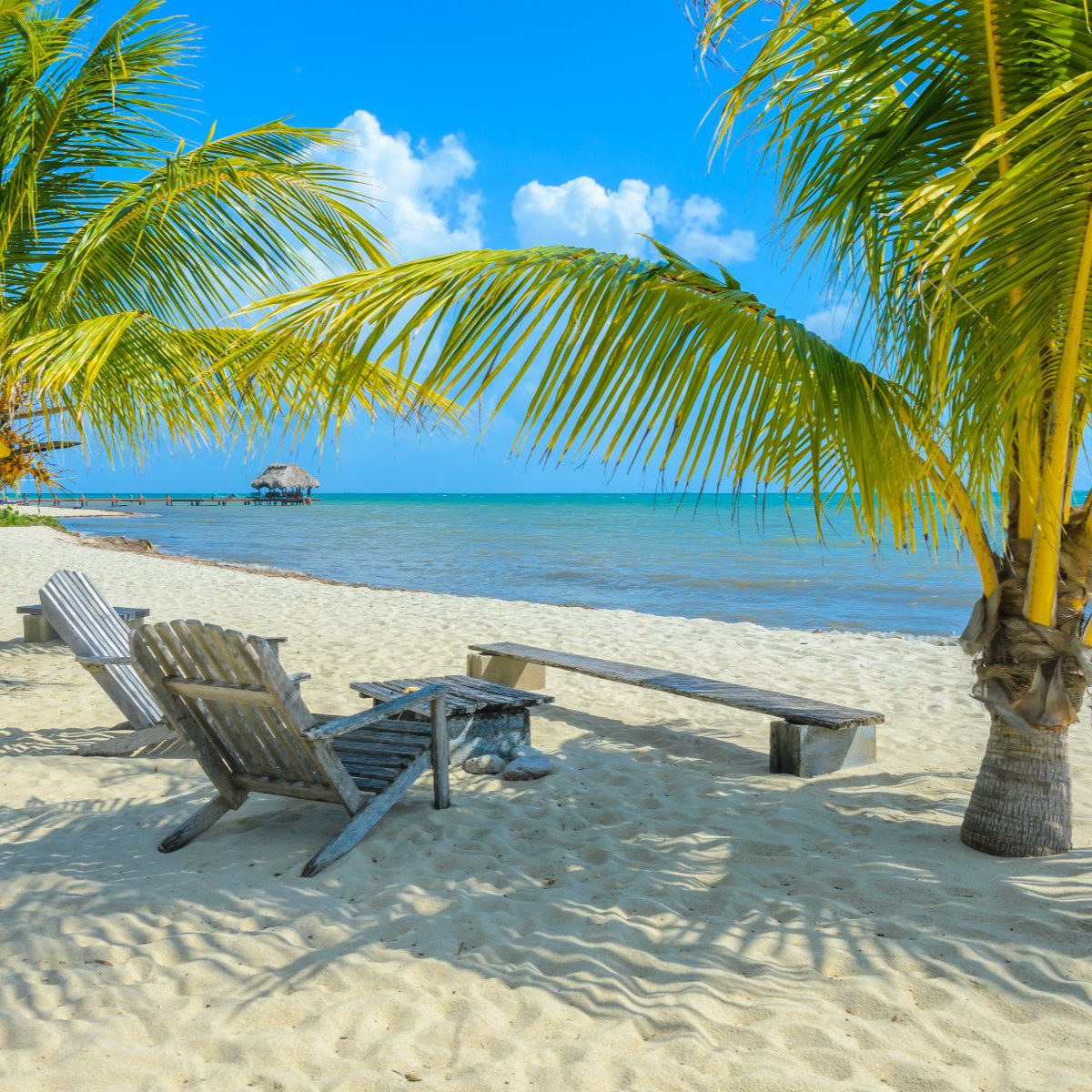 Rondreis-Belize-Placencia-Paradise-Beach-strand-met-palmbomen-en-ligstoelen