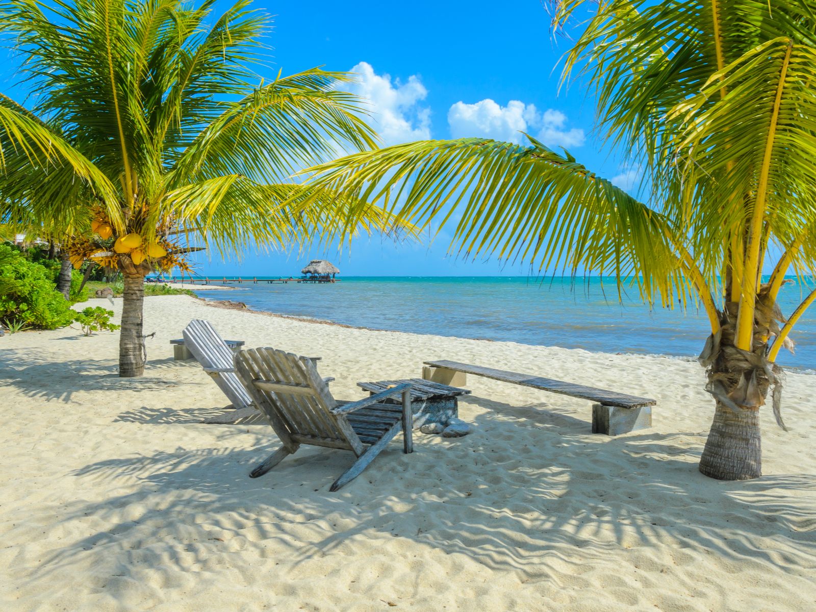 Rondreis Belize, Placencia, Paradise Beach strand met palmbomen en ligstoelen