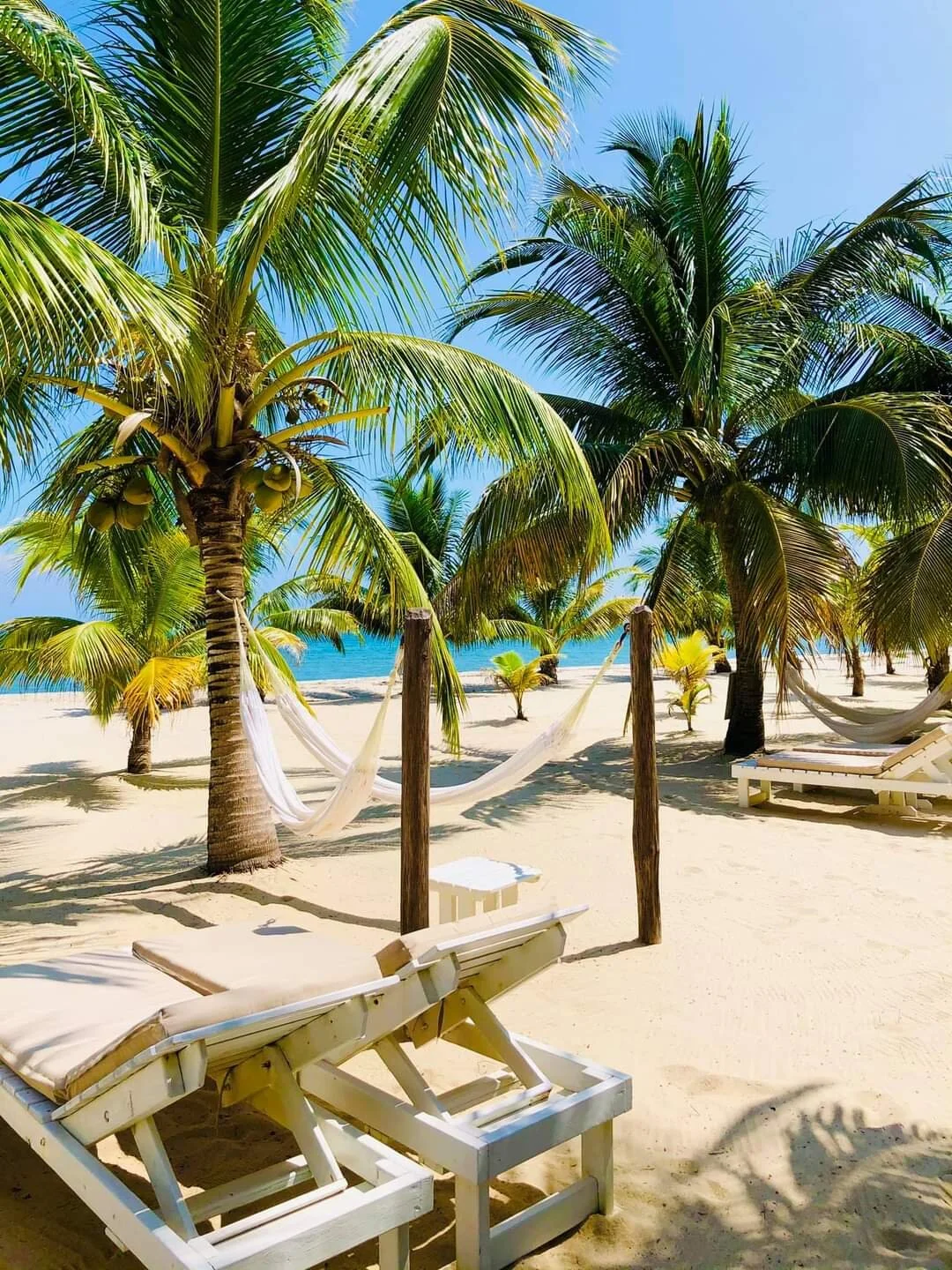 Rondreis Belize, Placenia, Carribean Beach Cabanas, strand met hangmatten en strandbedden