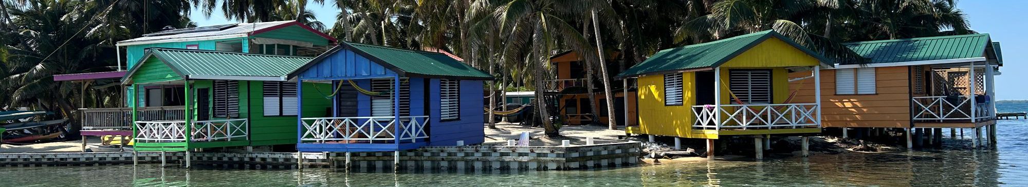 Rondreis-Belize-Tobacco-Caye-kleurige-houten-huisjes-aan-het-strand