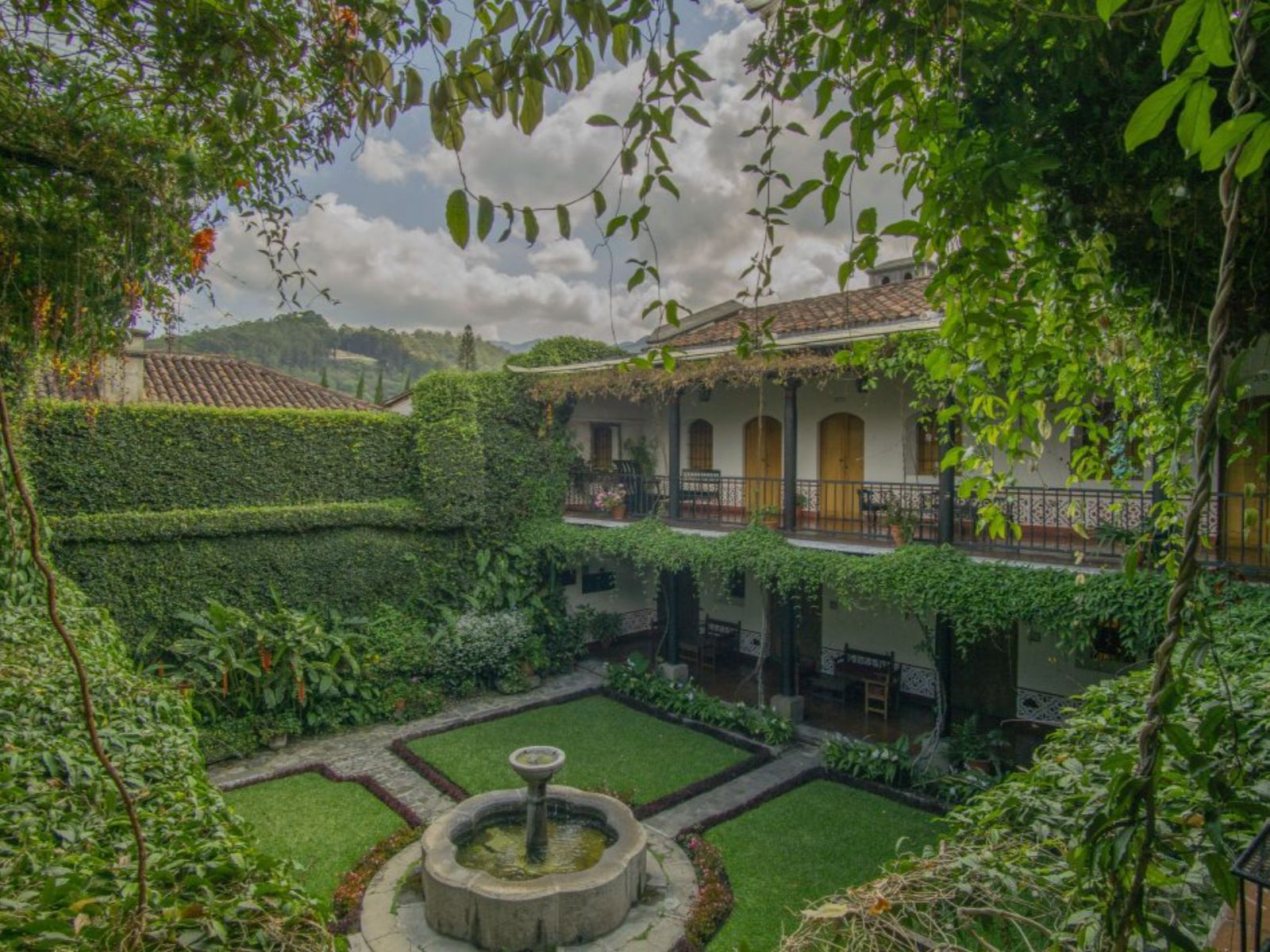 Rondreis Guatemala, Antigua, Posada de don Rodrigo Hotel, binnenplaats met hotelkamers