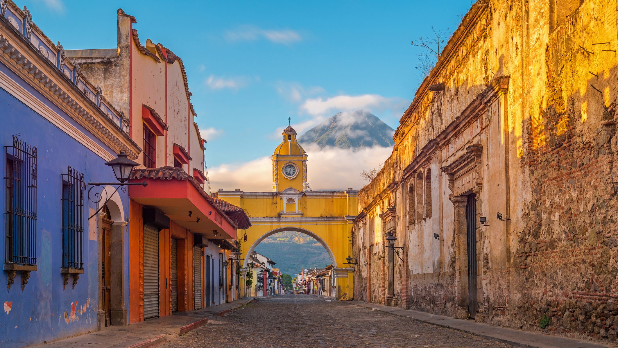 Rondreis Guatemala, Antigua, kleurige huizen met vulkaan op achtergrond