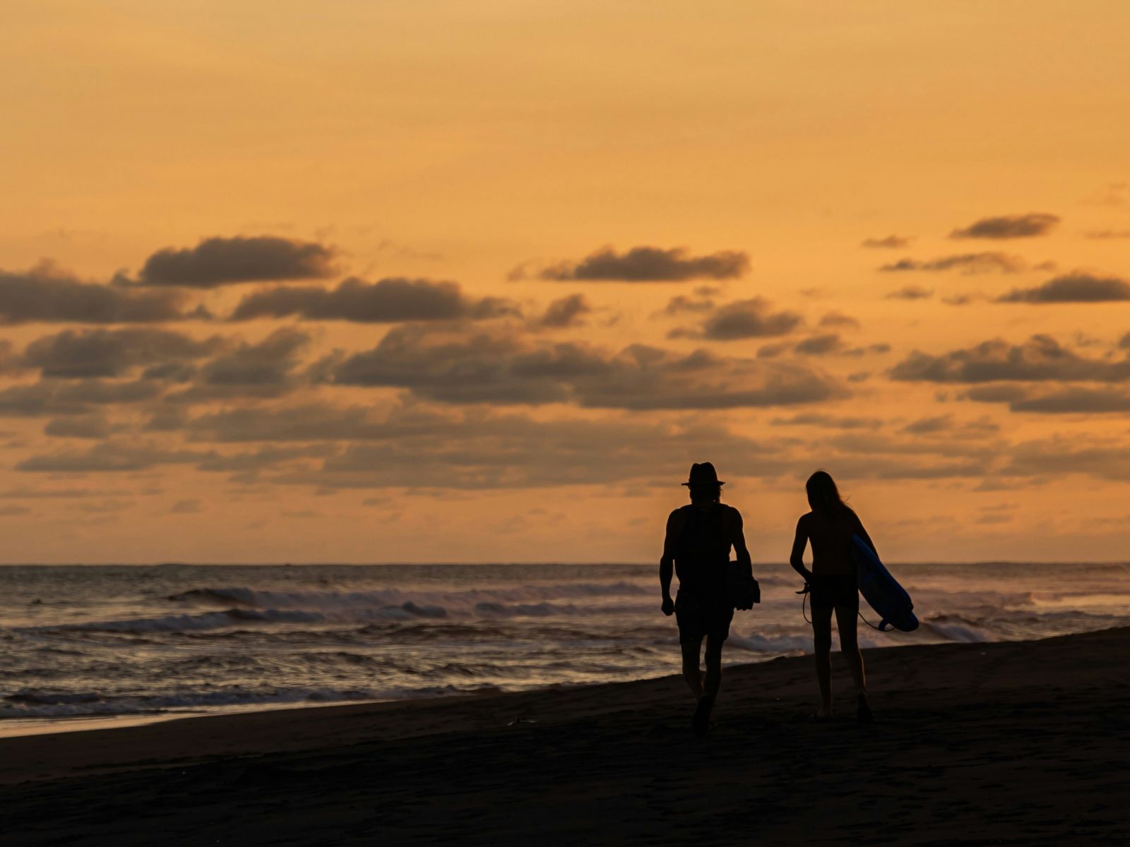 Rondreis Guatemala, El Paredon, mensen op strand met zonsondergang