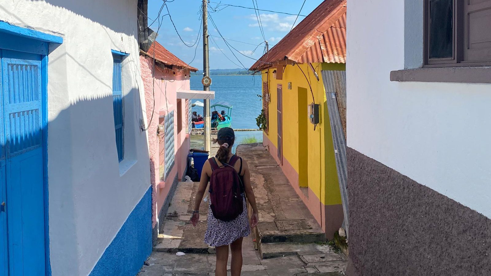 Rondreis Guatemala, Flores, vrouw loopt door kleurrijke straten