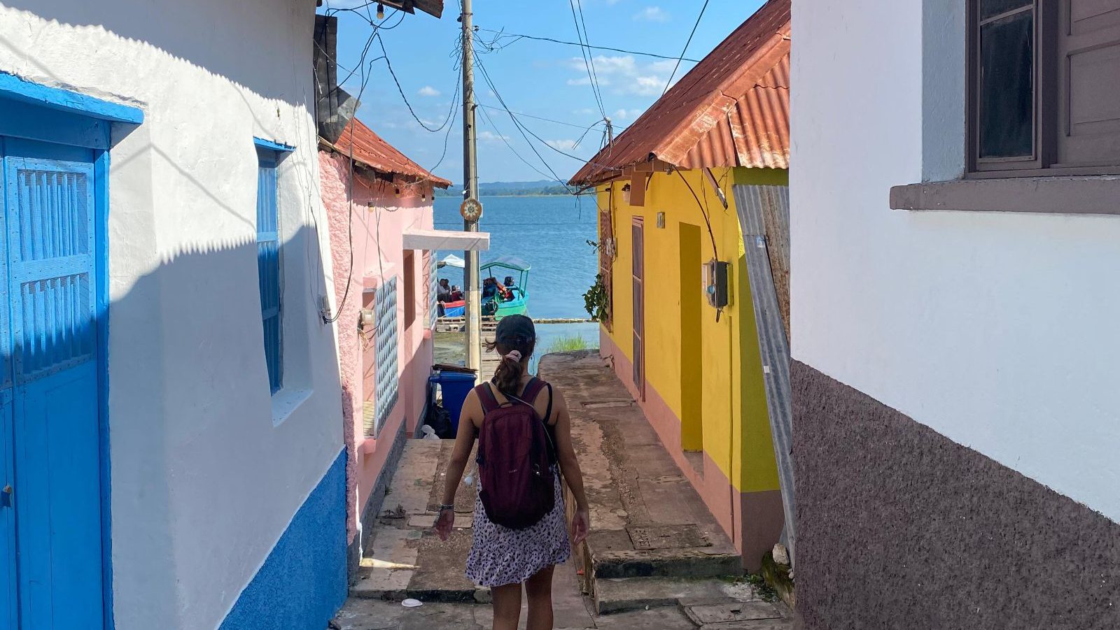 Rondreis Guatemala, Flores, vrouw loopt door kleurrijke straten