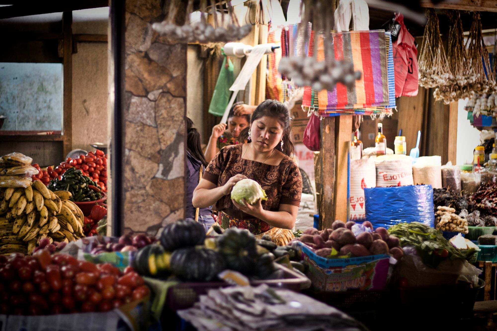 Rondreis Guatemala, vrouw bij kraampje met groente