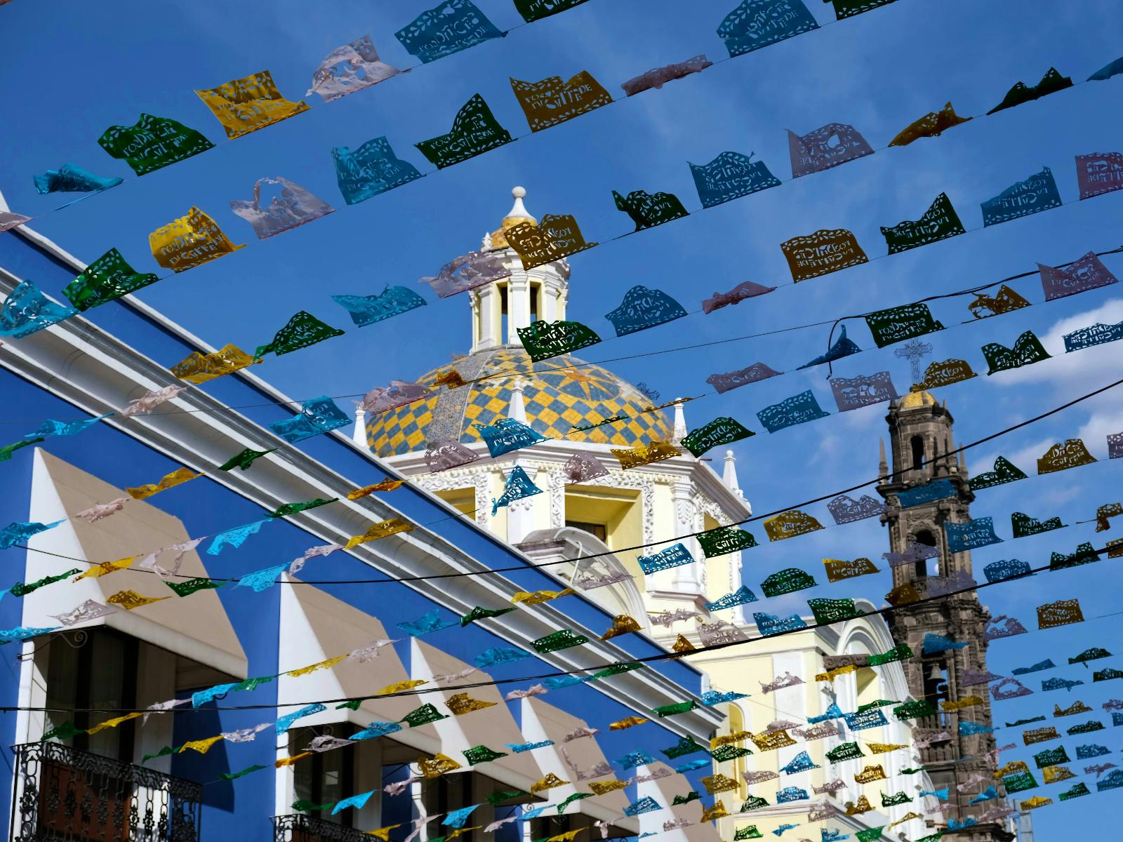 Rondreis Mexico, Puebla, vlaggen met kerktoren en blauwe lucht