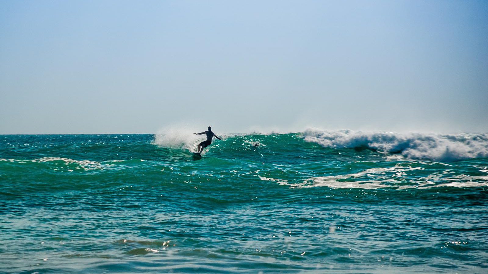 Rondreis Mexico, Puerto Escondido, surfer in de zee