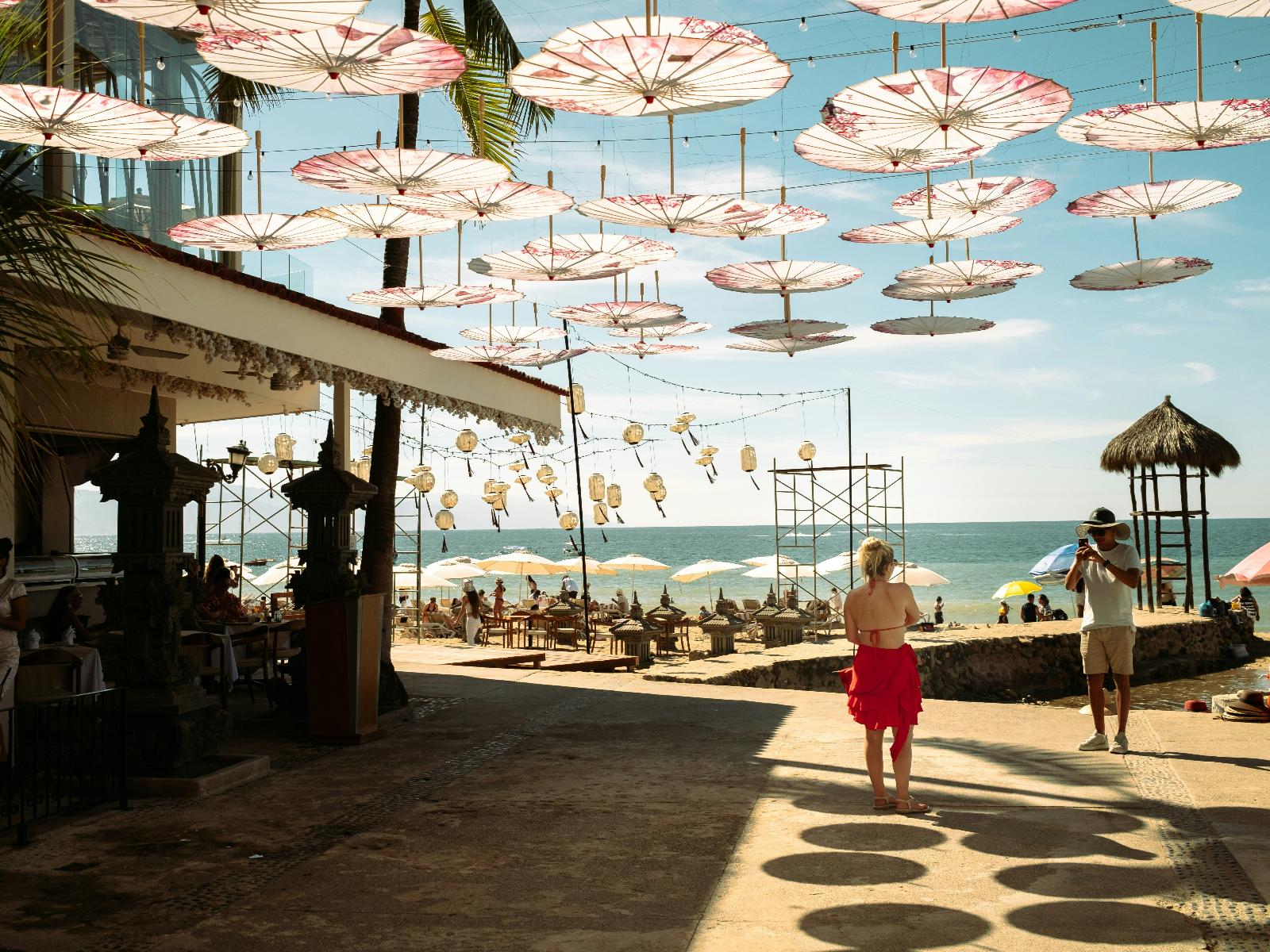 Rondreis Mexico, Puerto Vallarta, vrouw op boulevard met kleurrijke paraplu's