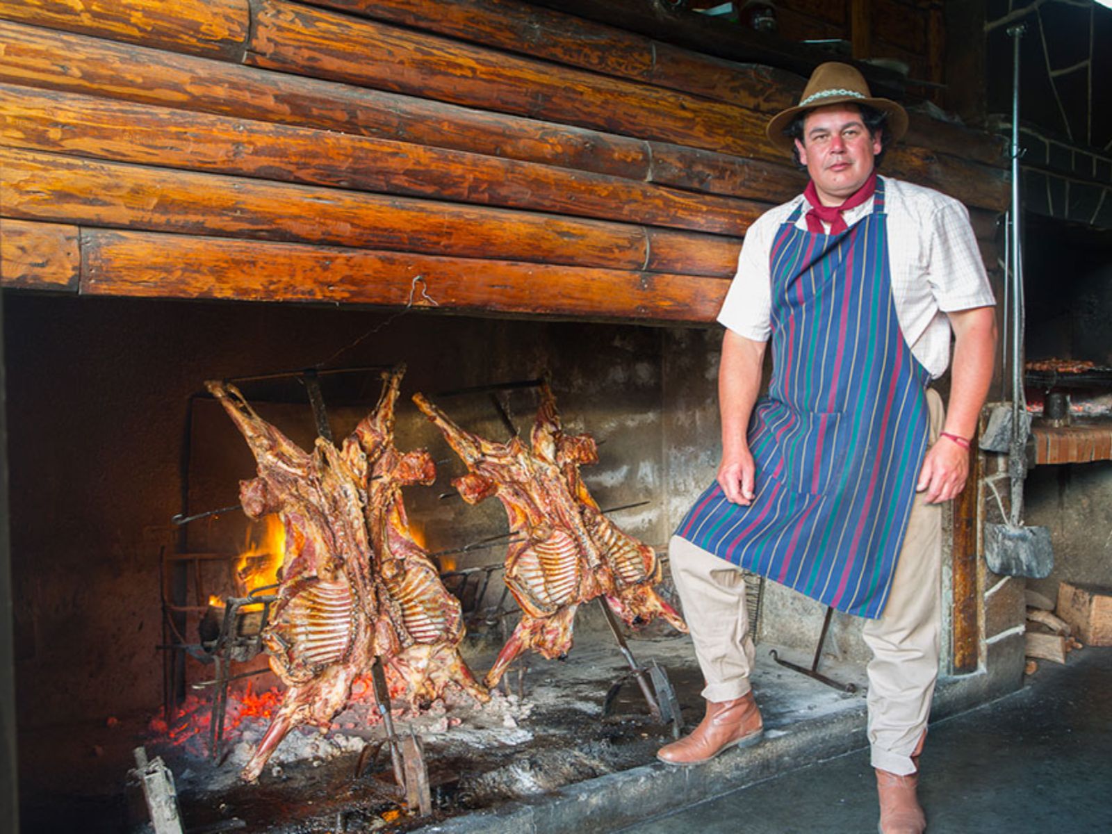 Rondreis Argentinië, El Calafate, excursie gaucho voor een dag, asado, chef met vlees op het vuur