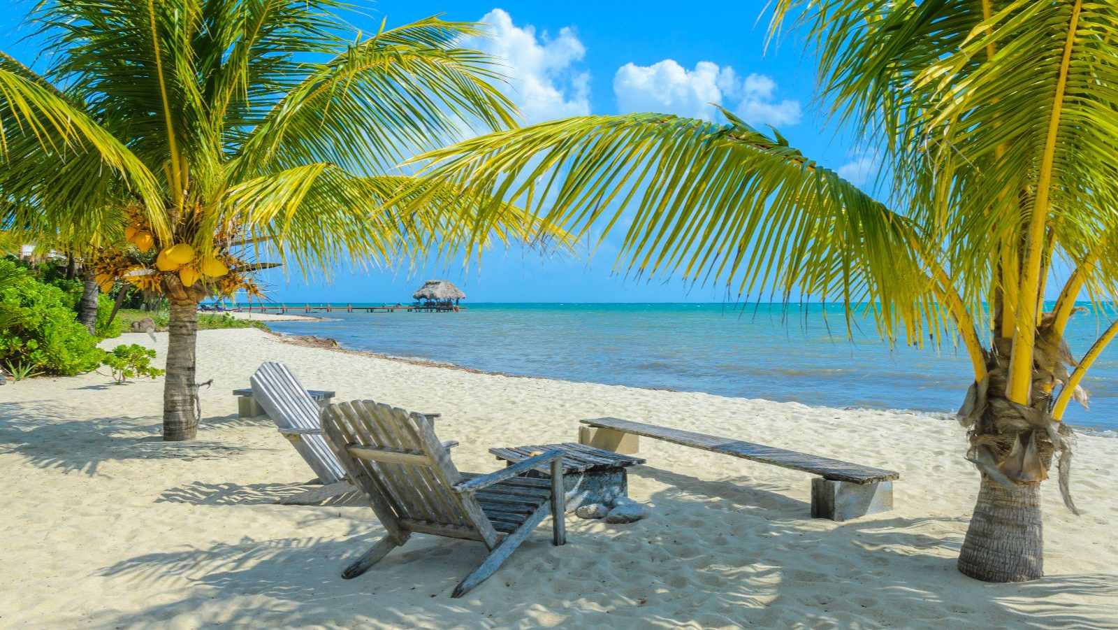 Rondreis Belize, Placencia, Paradise Beach strand met palmbomen en ligstoelen