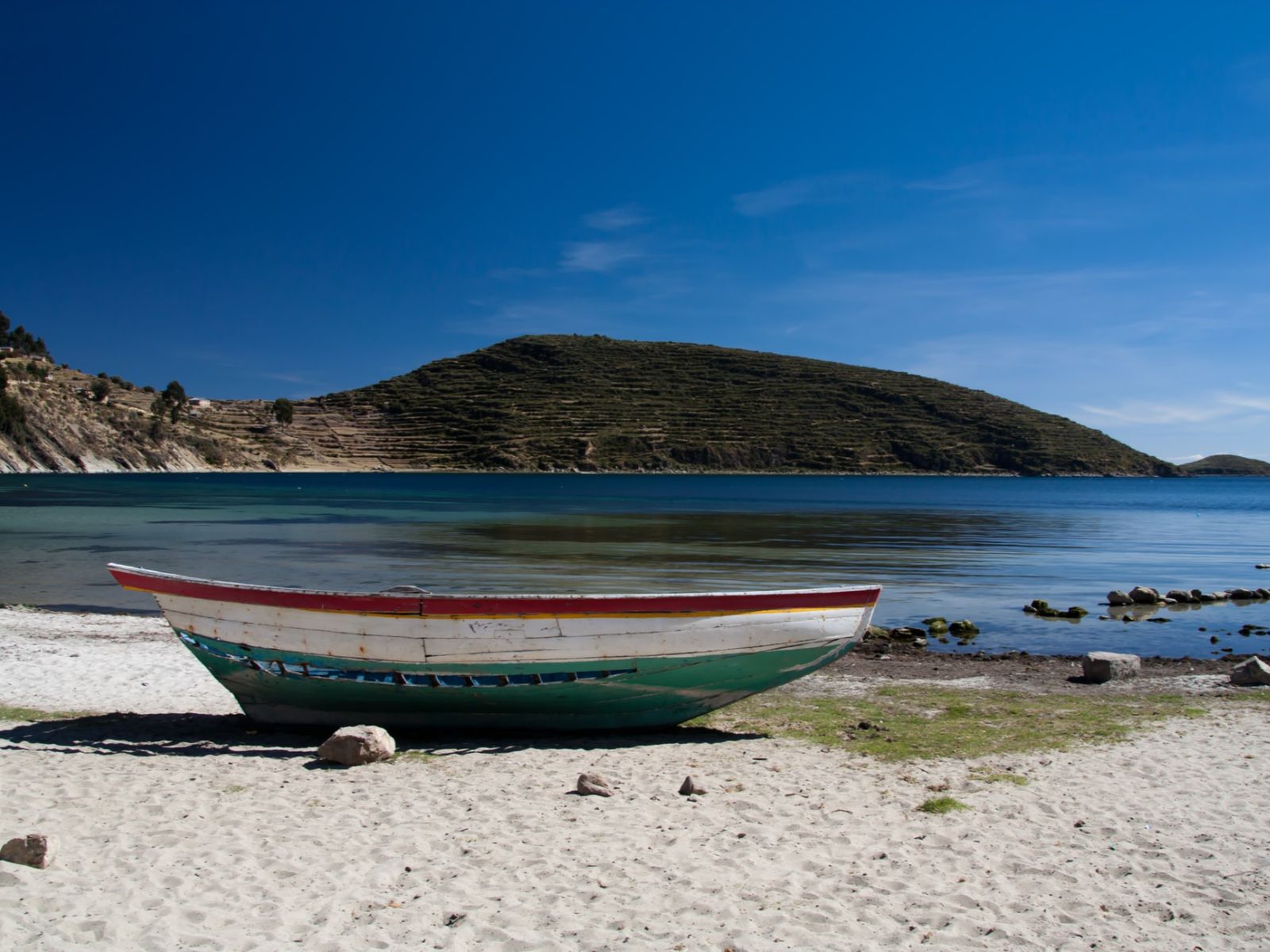 Rondreis Bolivia, Copacabana, excursie Mystiek Isla del Sol, zee met strand en boot op het strand