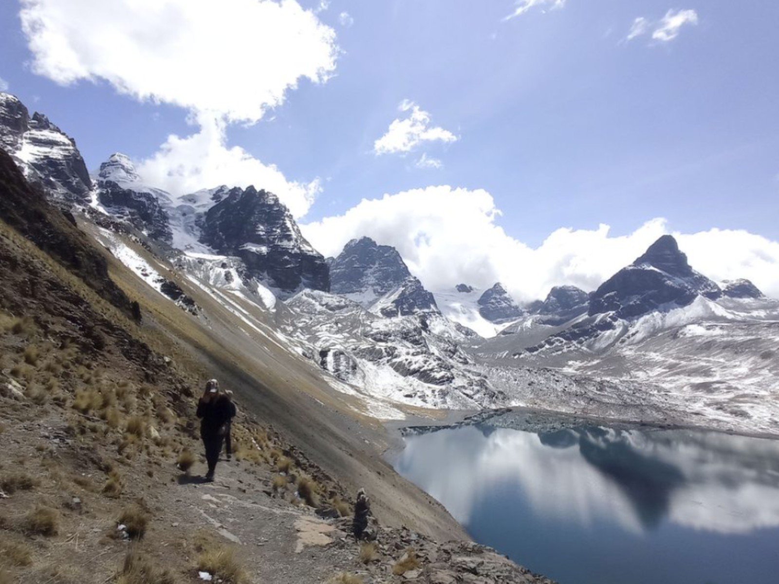 Rondreis Bolivia, La Paz, excursie beklimming bergtop Pico Austria, wandelaars met rechts een meer