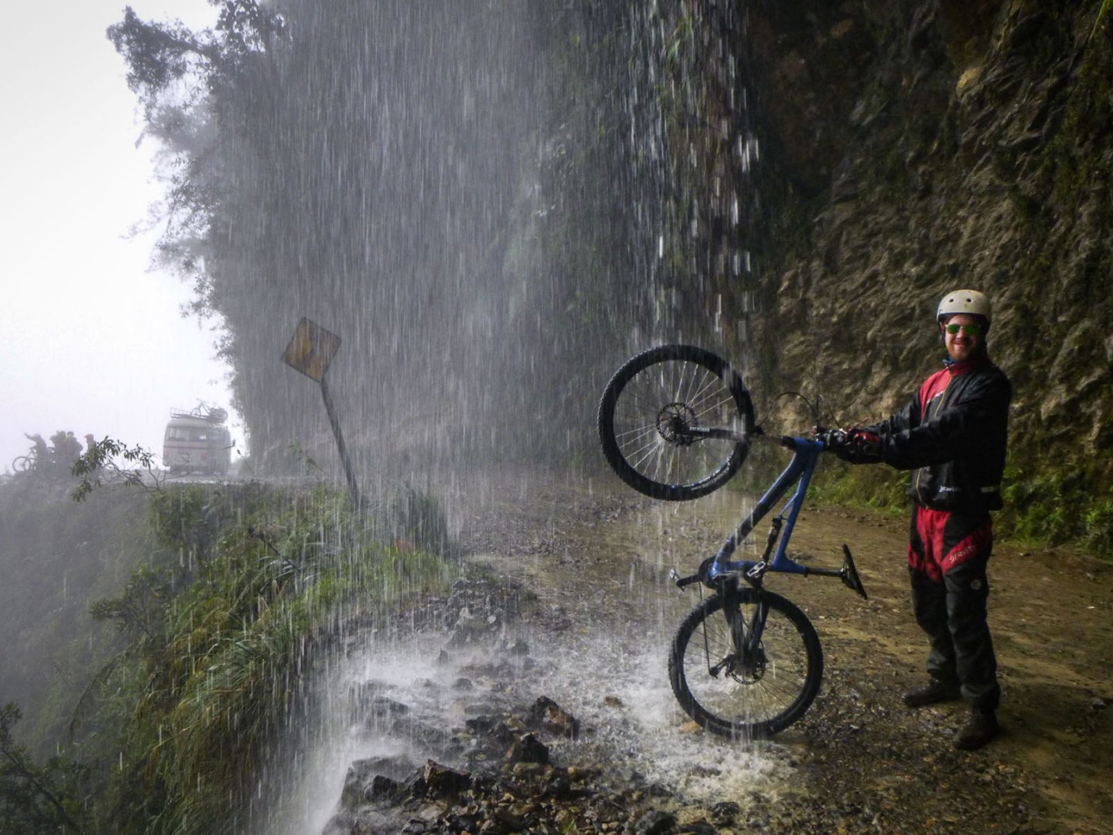 Rondreis Bolivia, La Paz, excursie mountainbiken Death Road, fietser onder waterval op Death Road