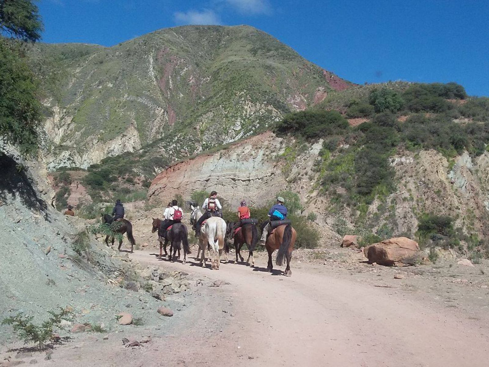 Rondreis Bolivia, Sucre, excursie te paard door de bergen rond Sucre, groepje mensen aan het paarrijden op de weg