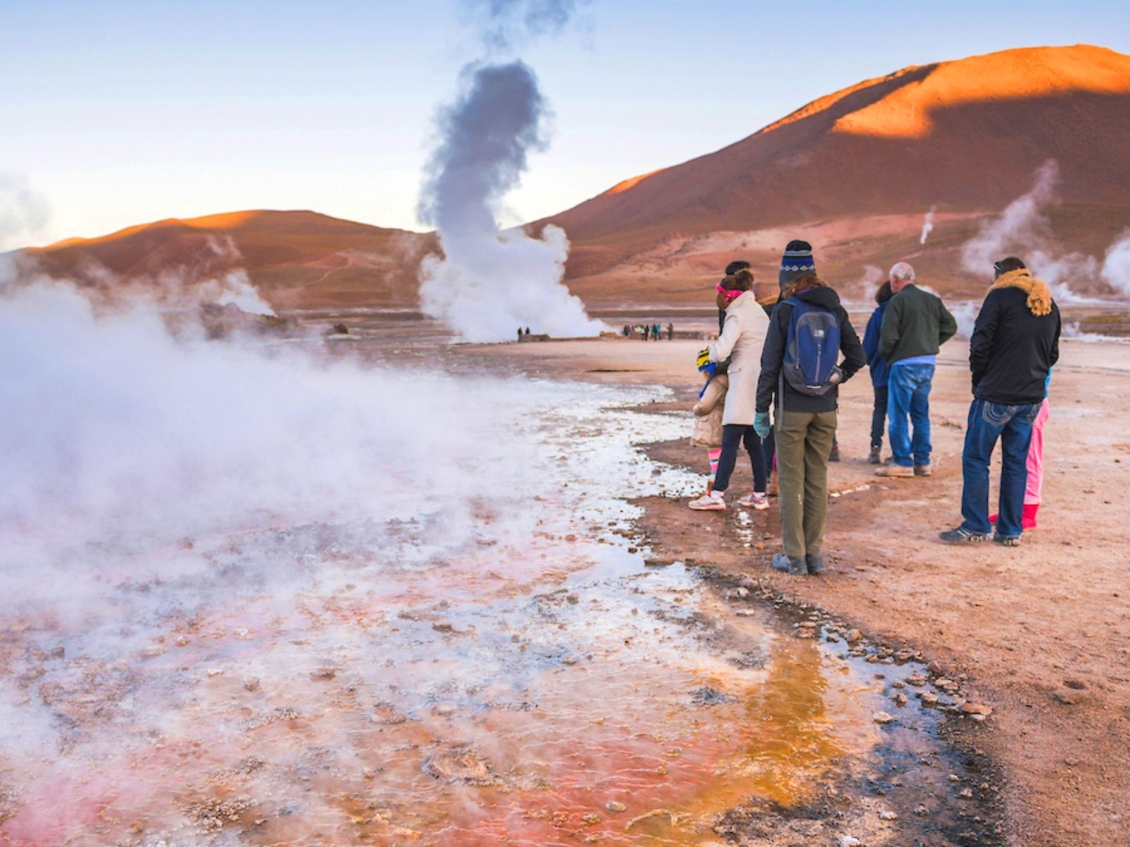 Rondreis Chili, San Pedro de Atacama, excursie stoom en zonsopgang bij Tatio geisers, mensen naast de roze geiser
