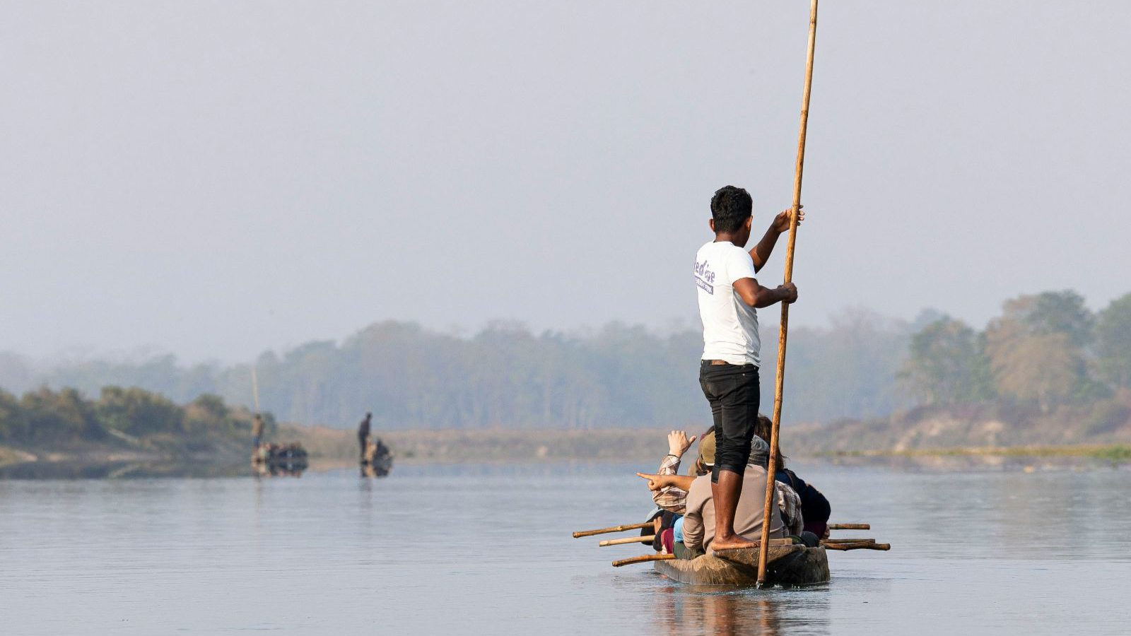 Rondreis Nepal, Chitwan, man die bootje duwt met stok