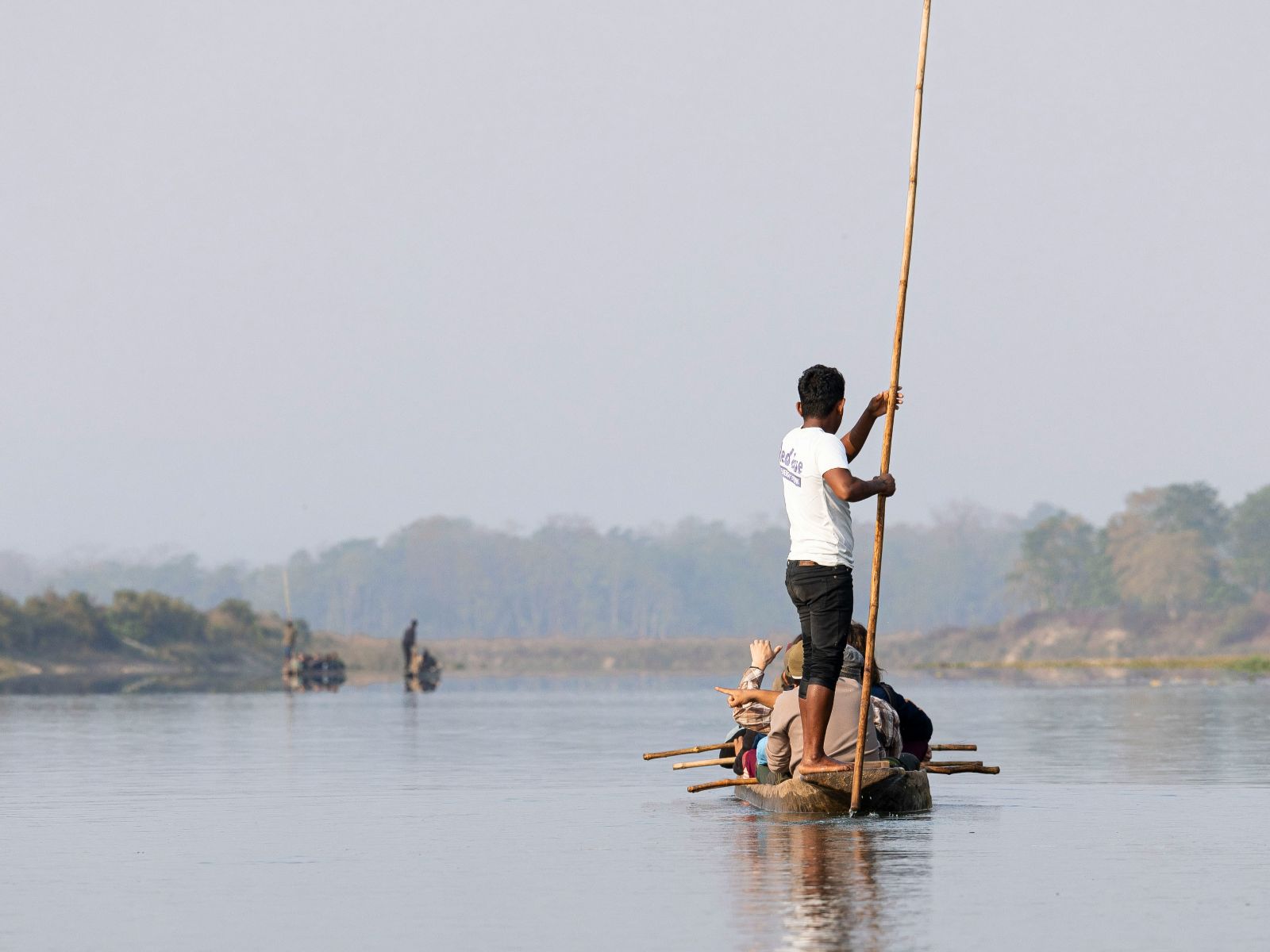 Rondreis Nepal, Chitwan, man die bootje duwt met stok