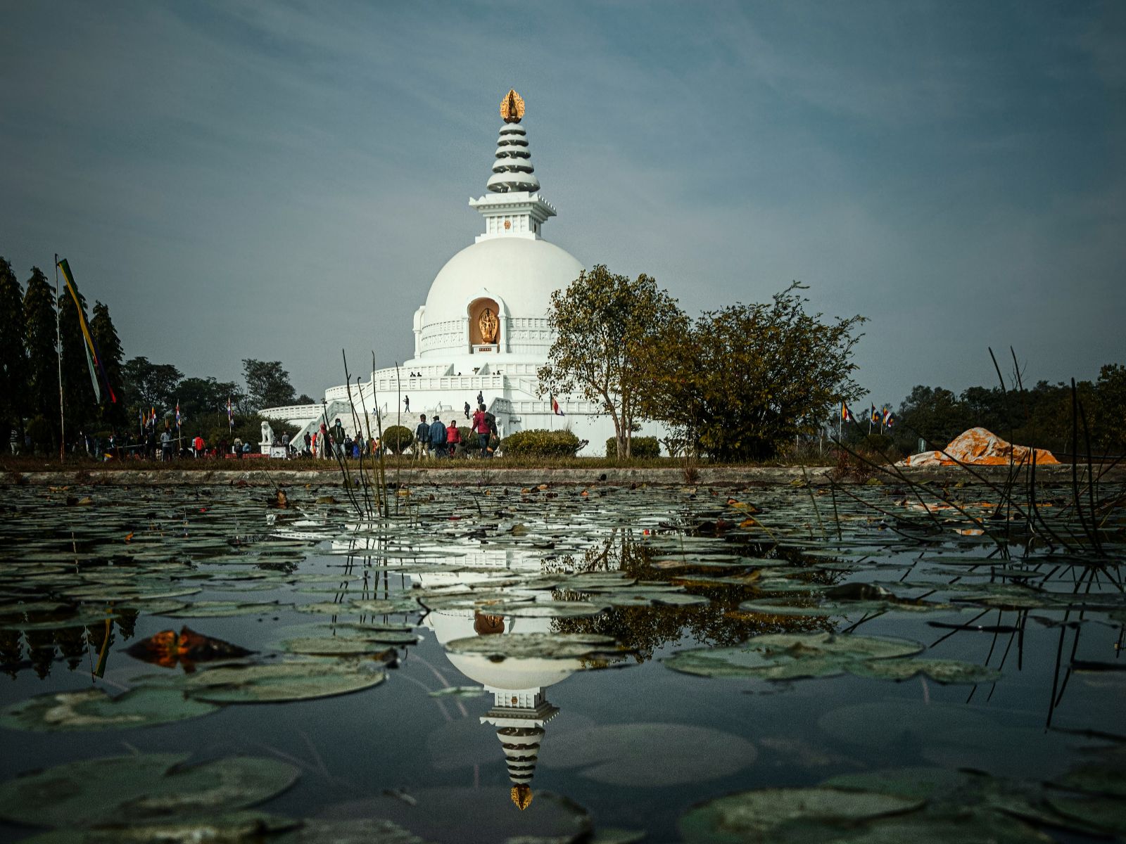 Rondreis Nepal, Lumbini, World Peace Pagoda, met water op de voorgrond