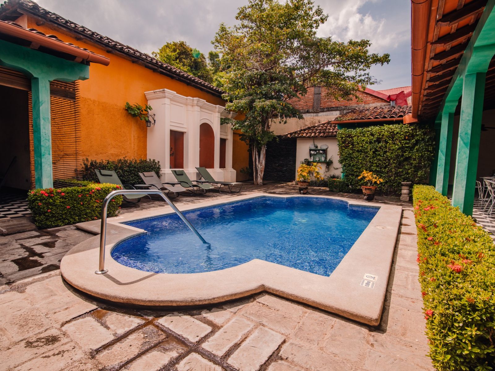 Rondreis Nicaragua, León, El Convento, buitenzwembad met ligstoelen en terras aan de zijkant