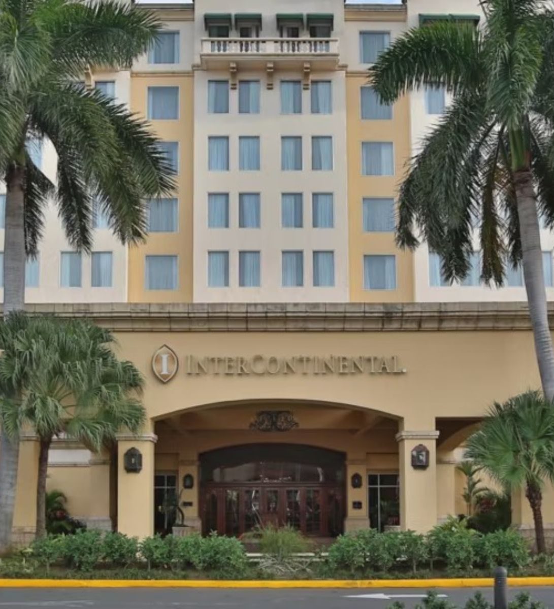 Rondreis Nicaragua, Managua, Real Intercontinental Metrocentro, vooraanzicht hotel en ingang met oprit en palmbomen