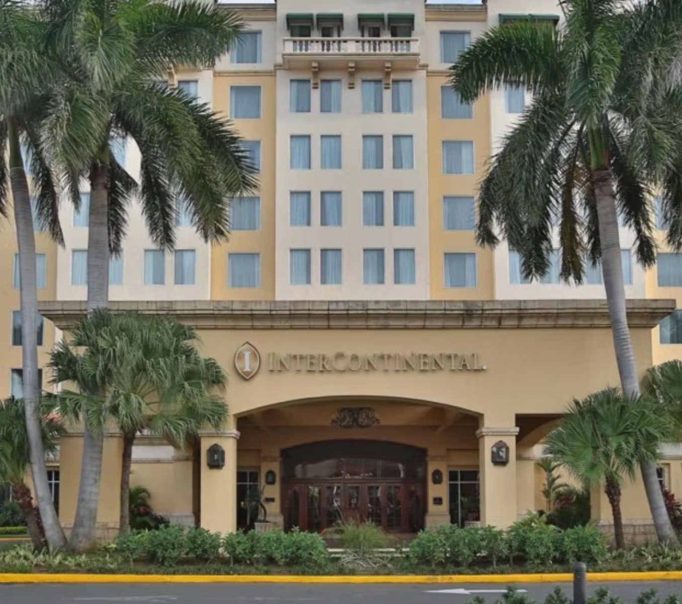 Rondreis Nicaragua, Managua, Real Intercontinental Metrocentro, vooraanzicht hotel en ingang met oprit en palmbomen