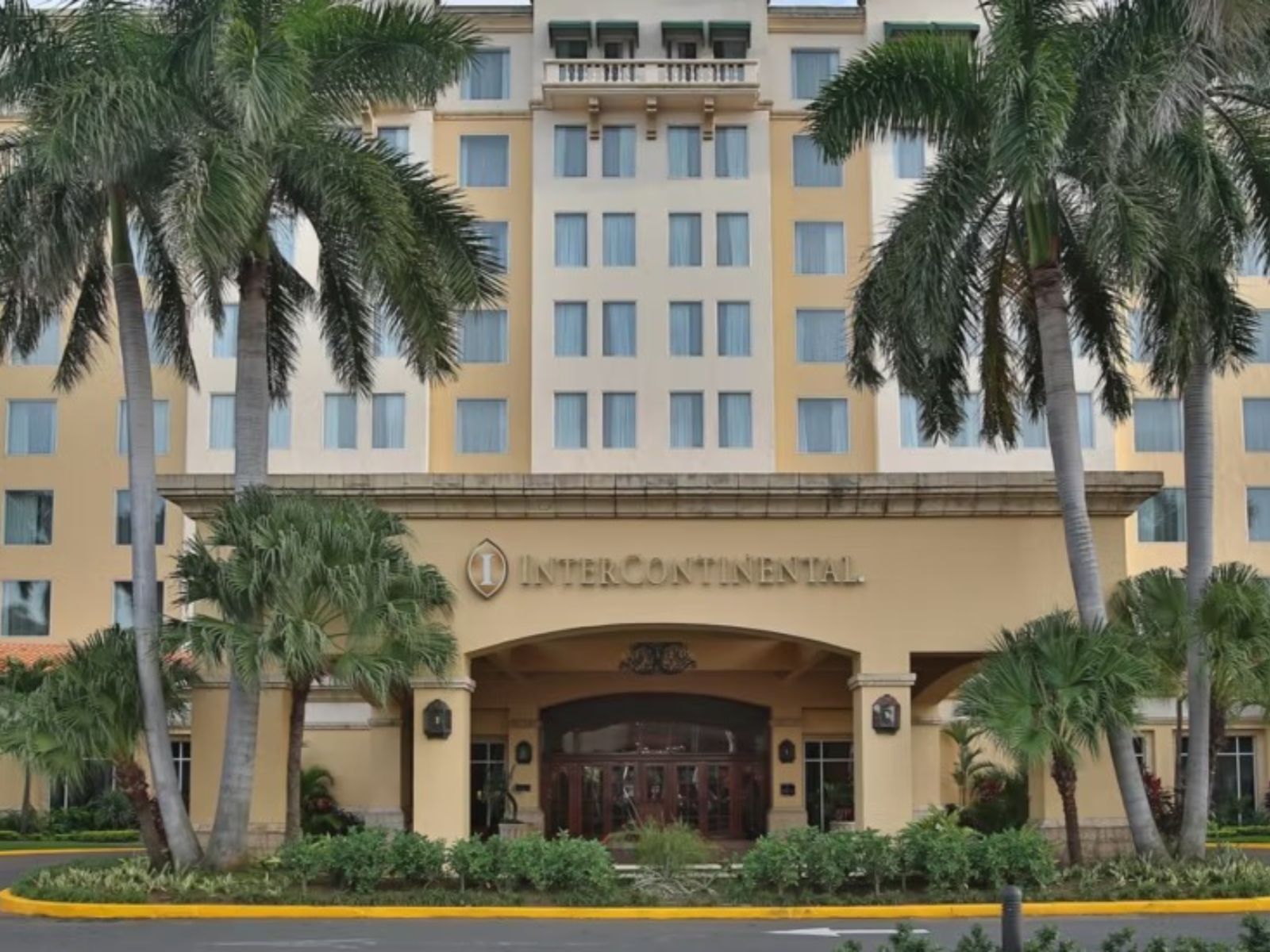 Rondreis Nicaragua, Managua, Real Intercontinental Metrocentro, vooraanzicht hotel en ingang met oprit en palmbomen