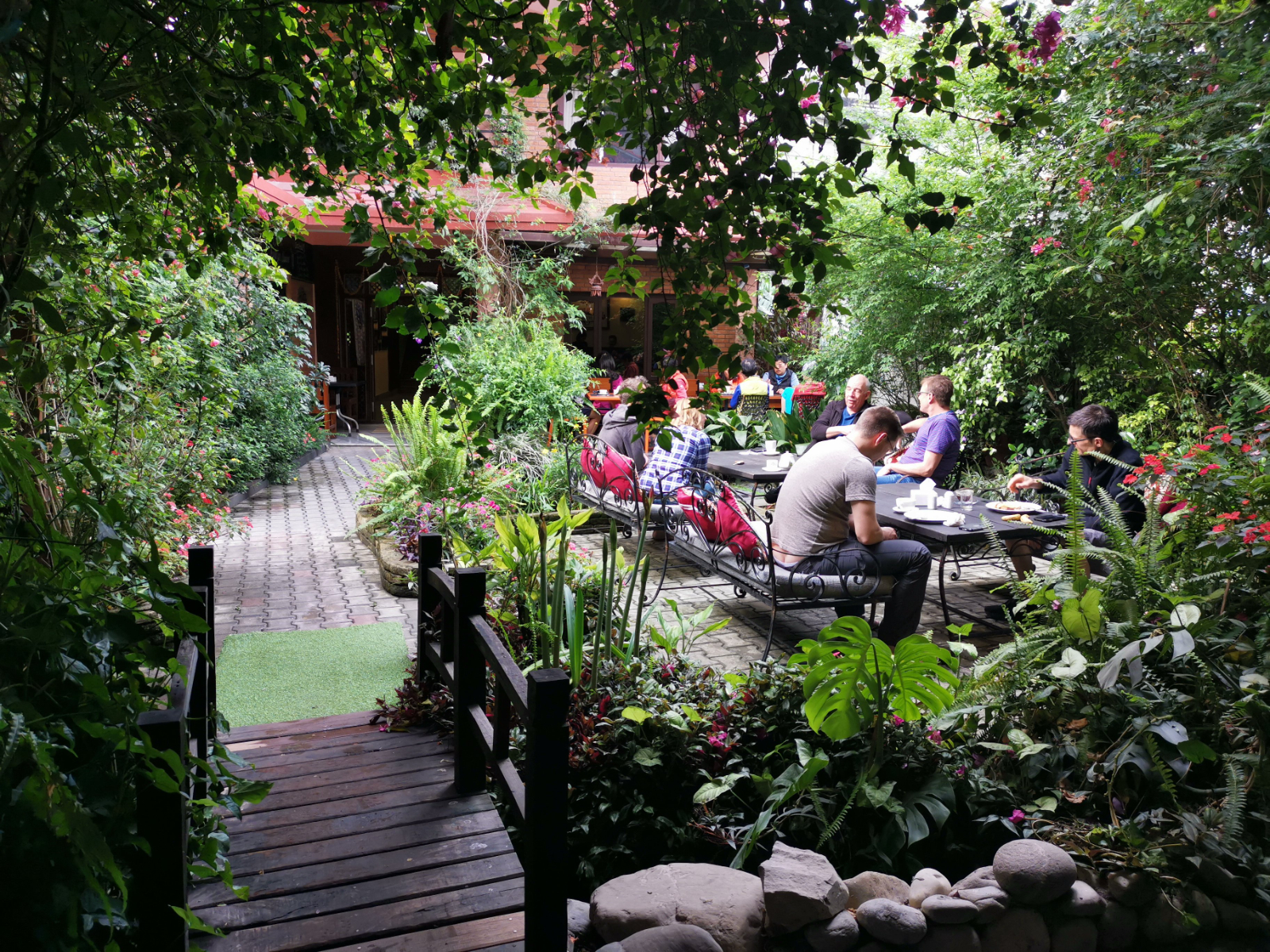 rondreis nepal, pokhara, hotel middle path, tuin met mensen