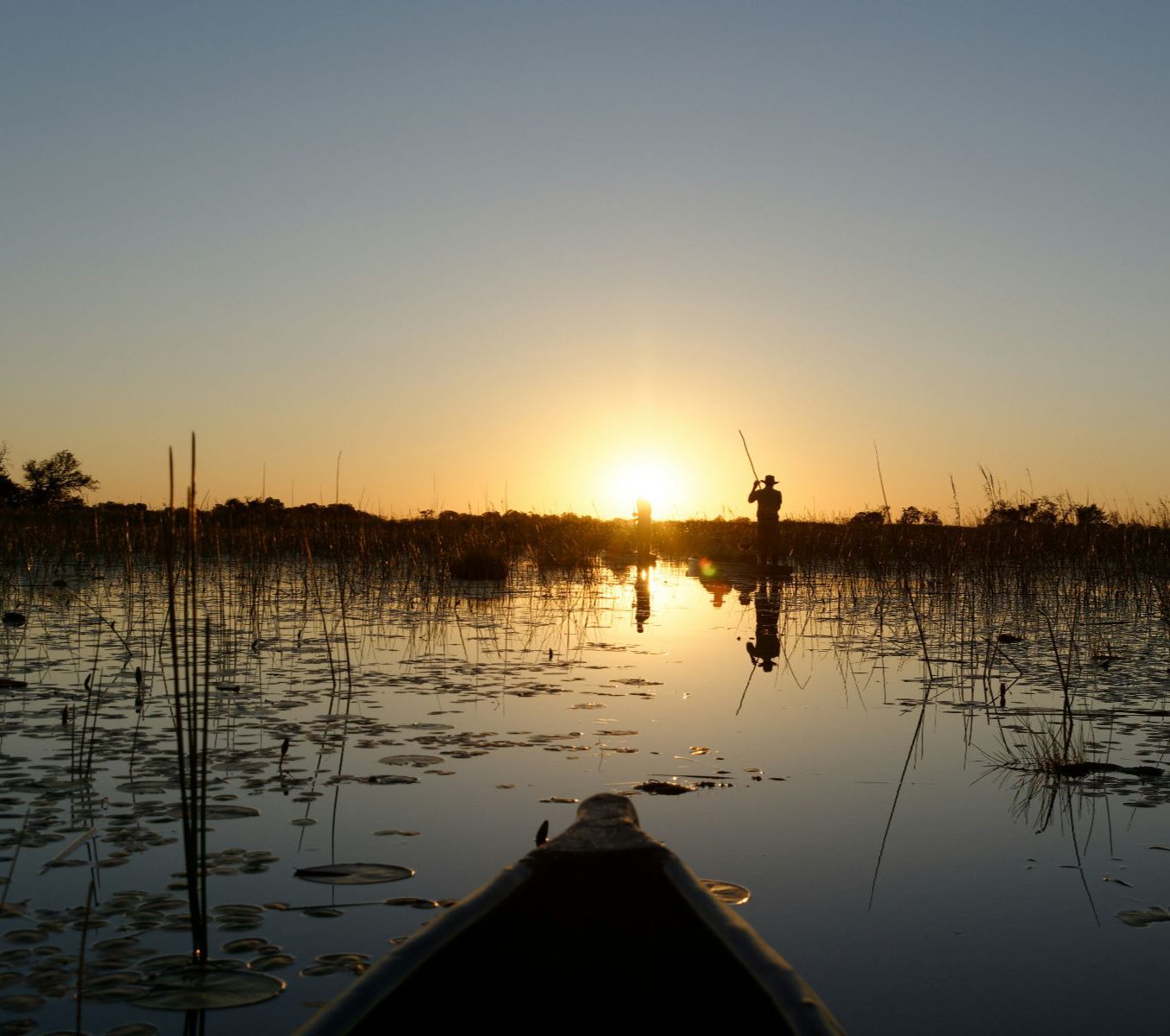 Rondreis Botswana, Maun, excursie Full Day Mokoro Tour, Bootje op de rivier met zonsondergang